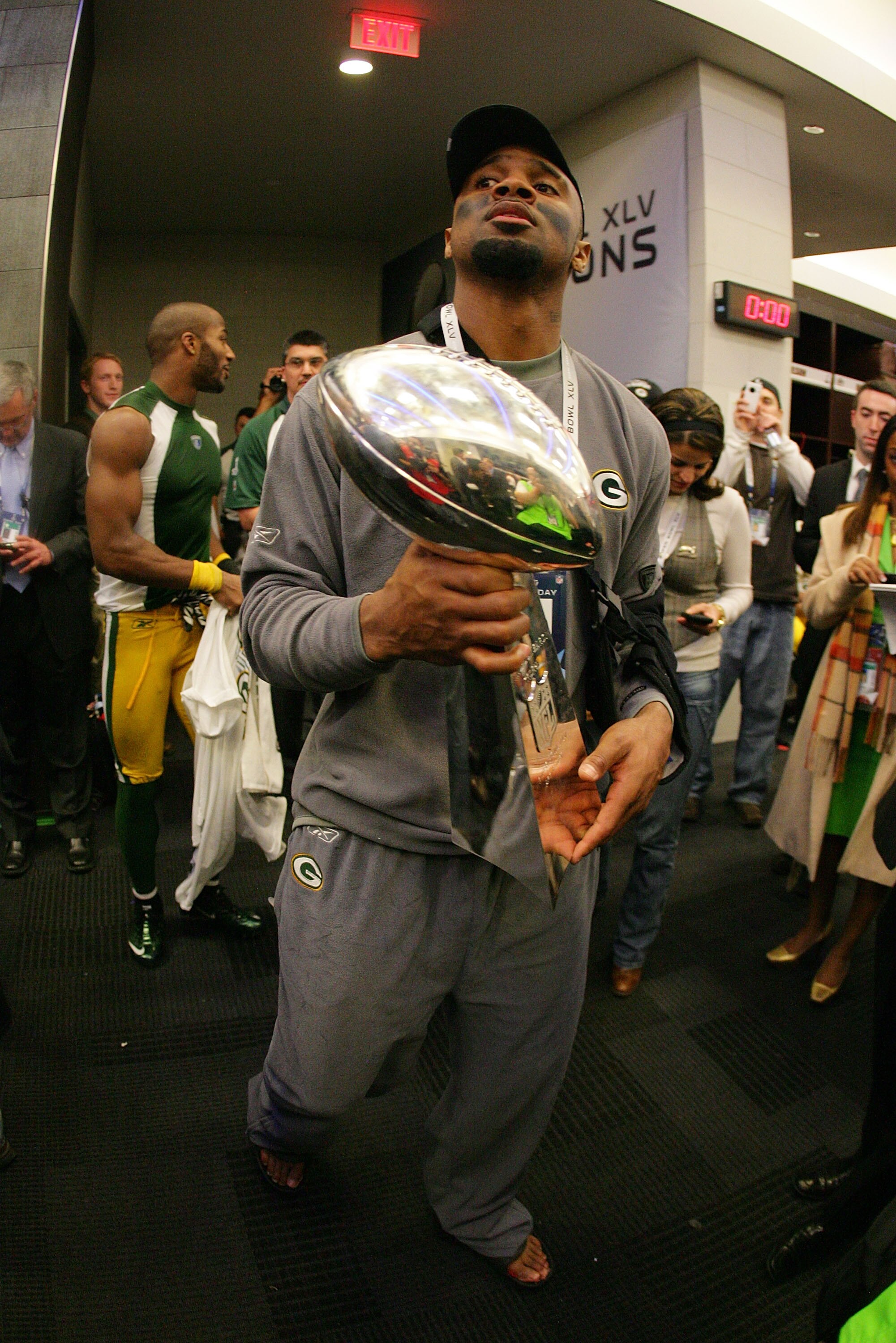ARLINGTON, TX - FEBRUARY 06:  Charles Woodson #21 of the Green Bay Packers celebrates in the locker room with the Vince Lombardi Trophy after winning Super Bowl XLV 31-25 against the Pittsburgh Steelers at Cowboys Stadium on February 6, 2011 in Arlington,