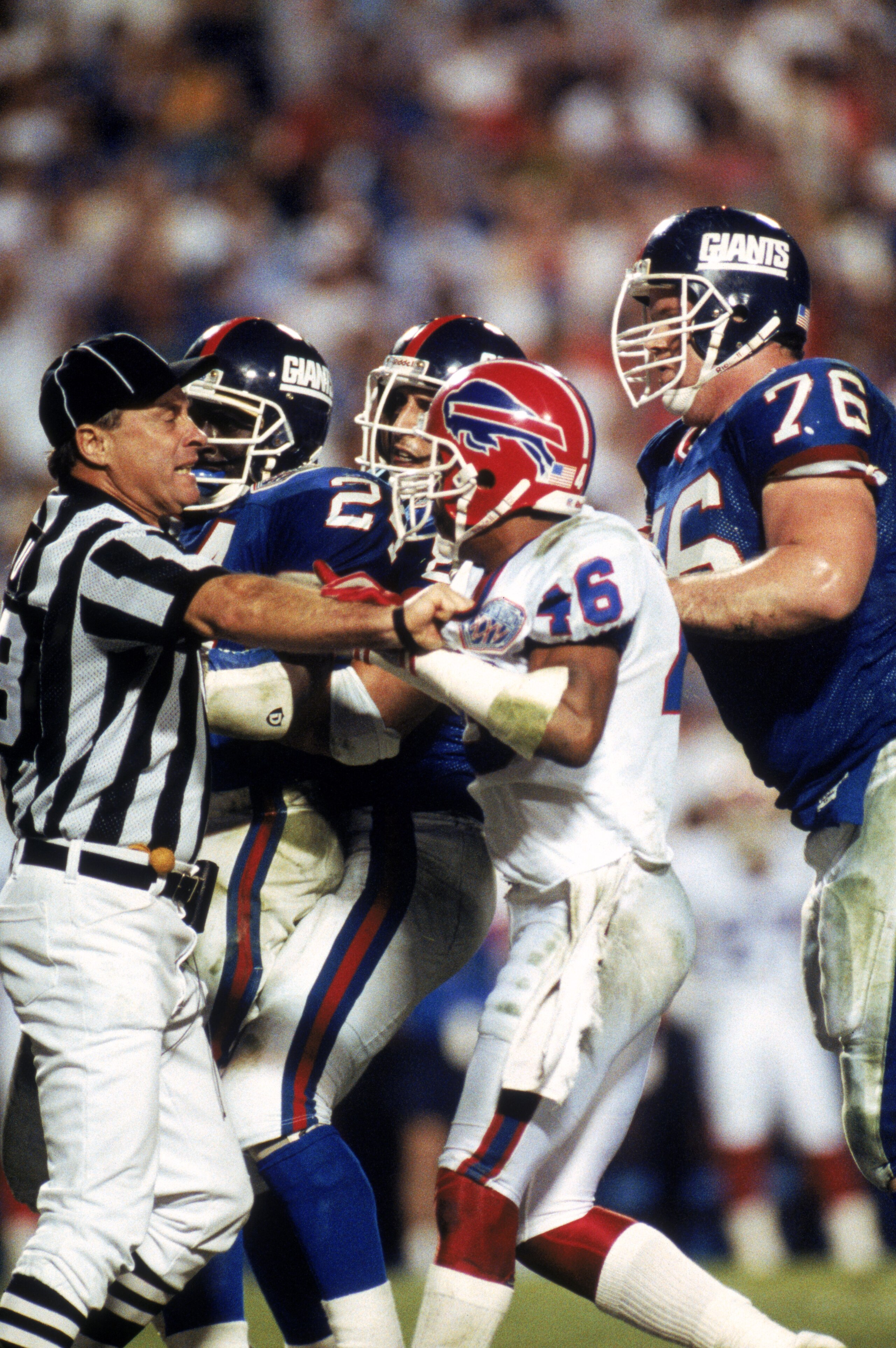 TAMPA, FL - JANUARY 27:  Umpire Art Demmas tries to separate defensive back Leonard Smith #46 of the Buffalo Bills and running back Ottis Anderson #26 of the New York Giants during Super Bowl XXV at Tampa Stadium on January 27, 1991 in Tampa, Florida.  Th