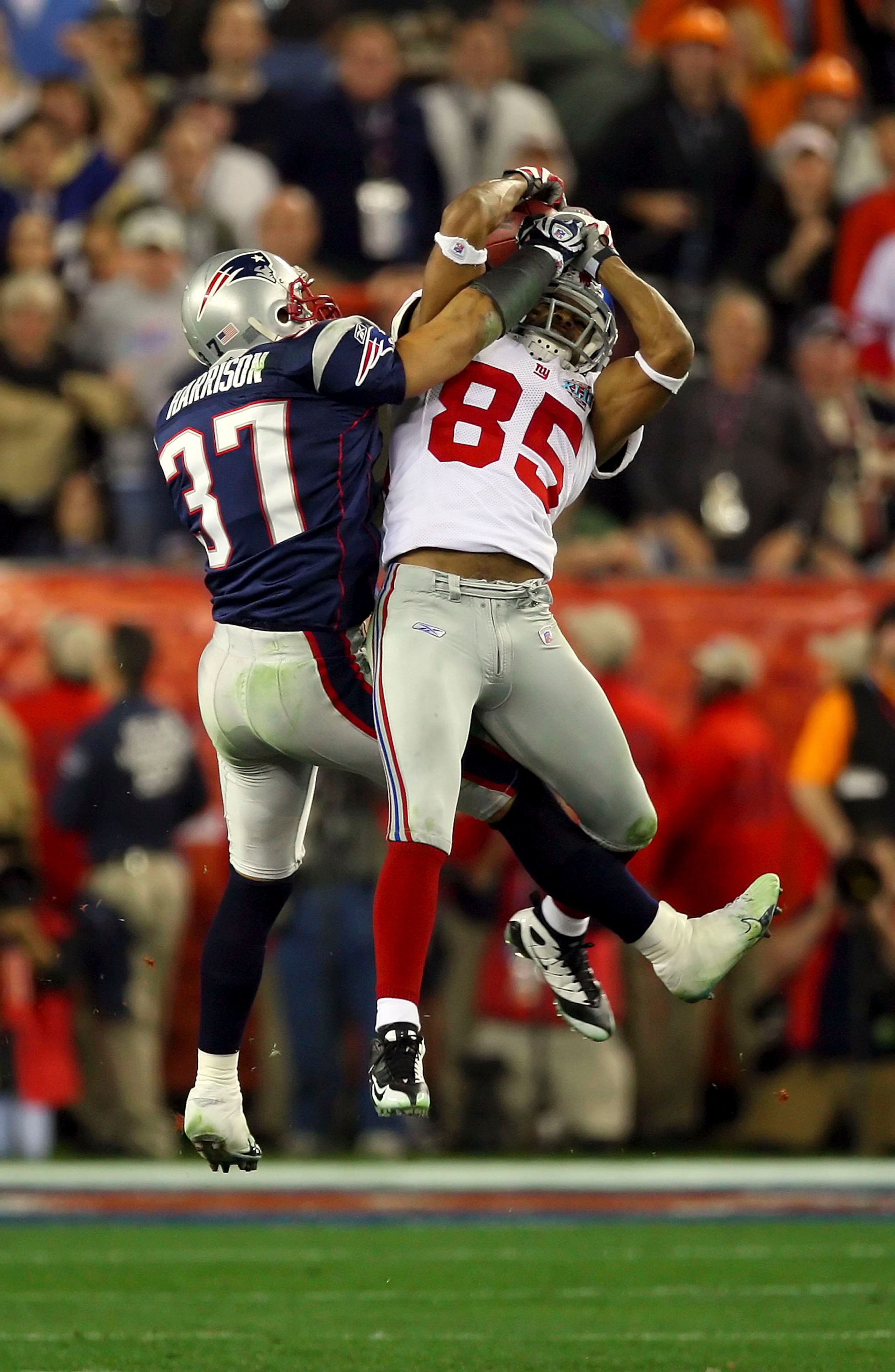 GLENDALE, AZ - FEBRUARY 03:  David Tyree #85 of the New York Giants catches a 32-yard pass from Eli Manning #10 as Rodney Harrison #37 of the New England Patriots attempts to knock it out in the fourth quarter of Super Bowl XLII on February 3, 2008 at the