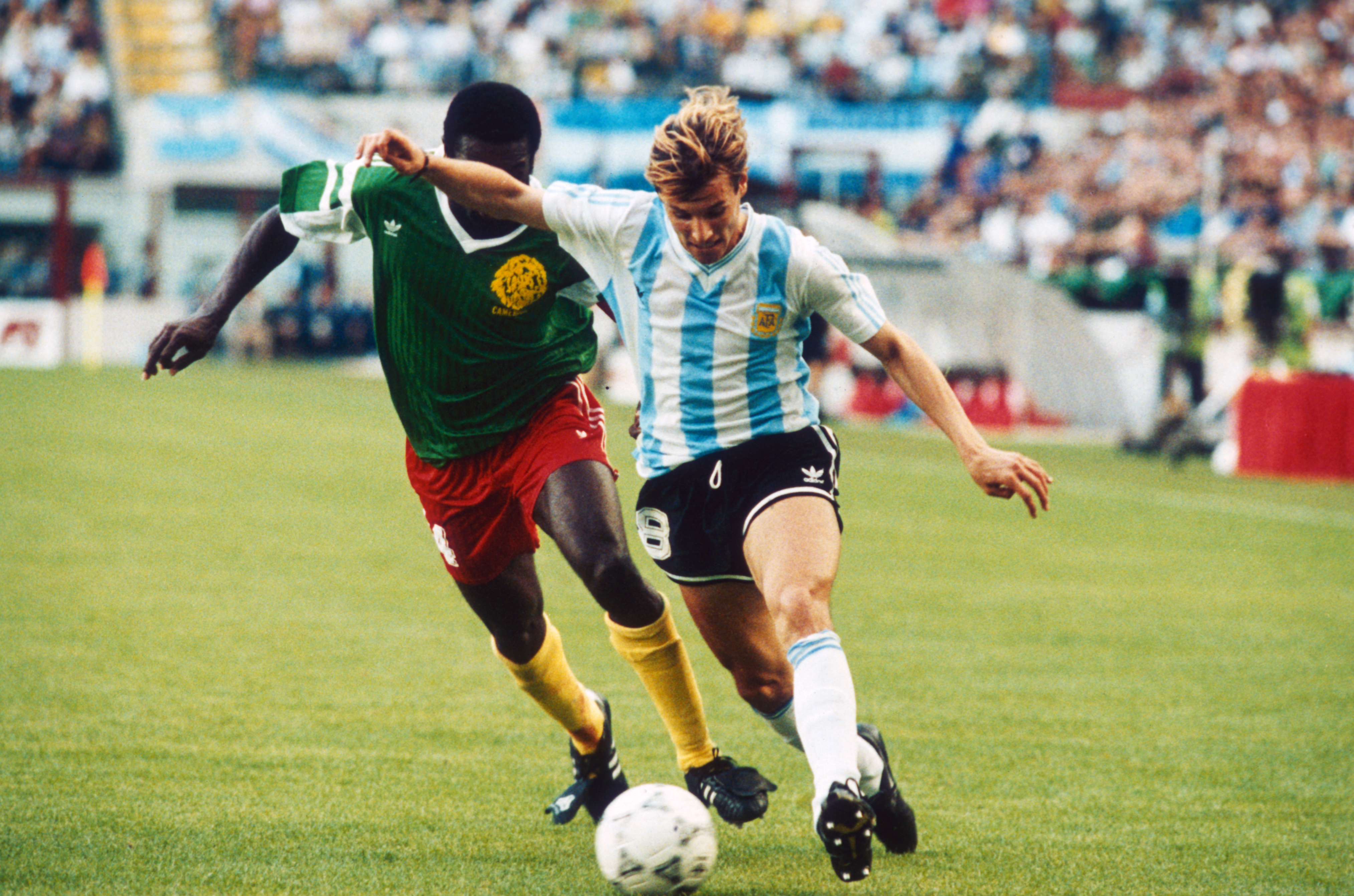 Argentinian footballer Claudio Caniggia is closely followed by the Cameroon player Benjamin Massing during their match at the 1990 World Cup in the Giuseppe Meazza stadium, Milan, 8th June 1990. (Photo by Getty Images)