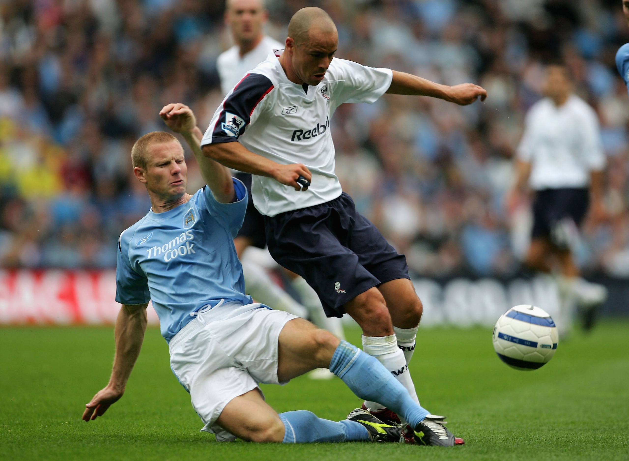 MANCHESTER, ENGLAND - SEPTEMBER 18:  Ben Thatcher of Manchester City tackles Stelios Giannakopoulos of Bolton Wanderers during the Barclays Premiership match between Manchester City and Bolton Wanderers at the City of Manchester Stadium on September 18, 2