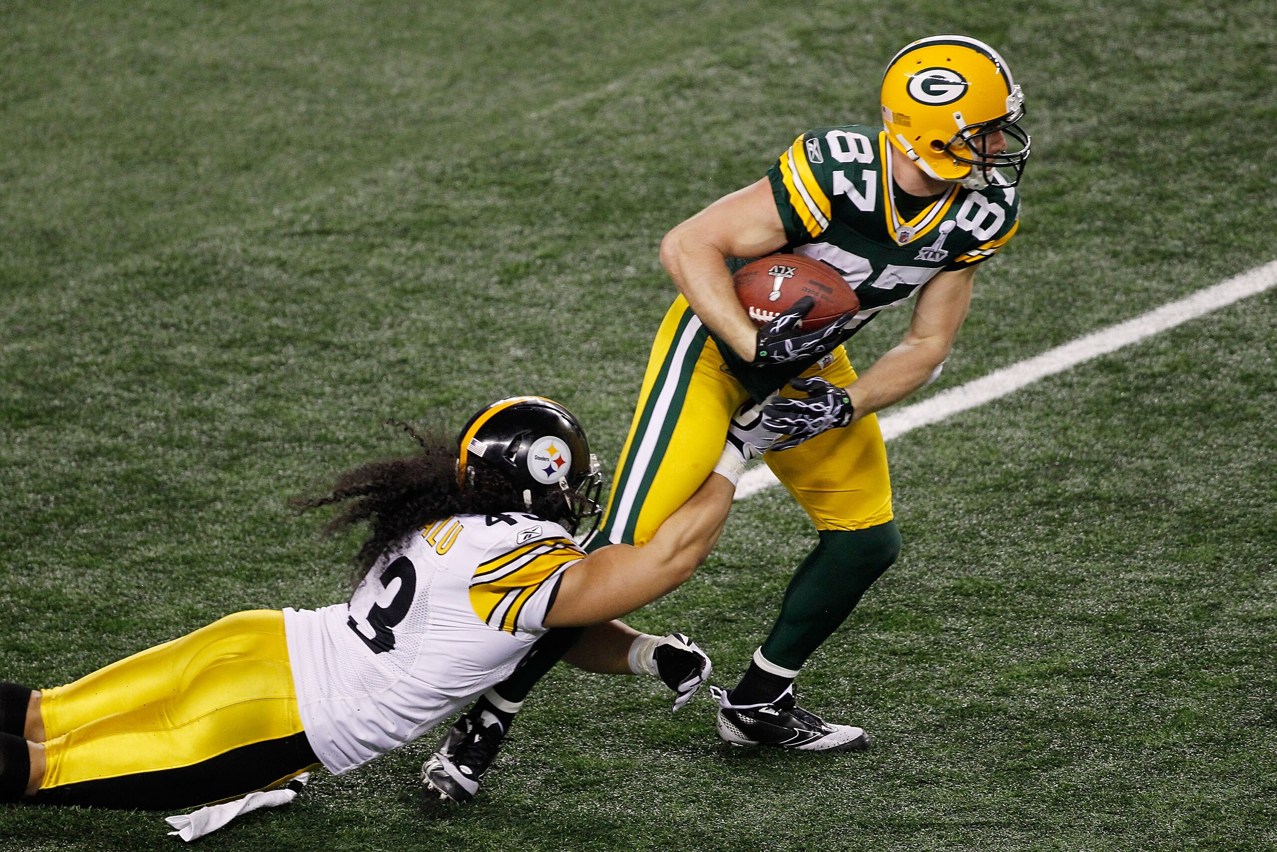 ARLINGTON, TX - FEBRUARY 06:  Jordy Nelson #87 of the Green Bay Packers tries to avoid the tackle of Troy Polamalu #43 of the Pittsburgh Steelers during Super Bowl XLV at Cowboys Stadium on February 6, 2011 in Arlington, Texas.  (Photo by Joe Robbins/Gett