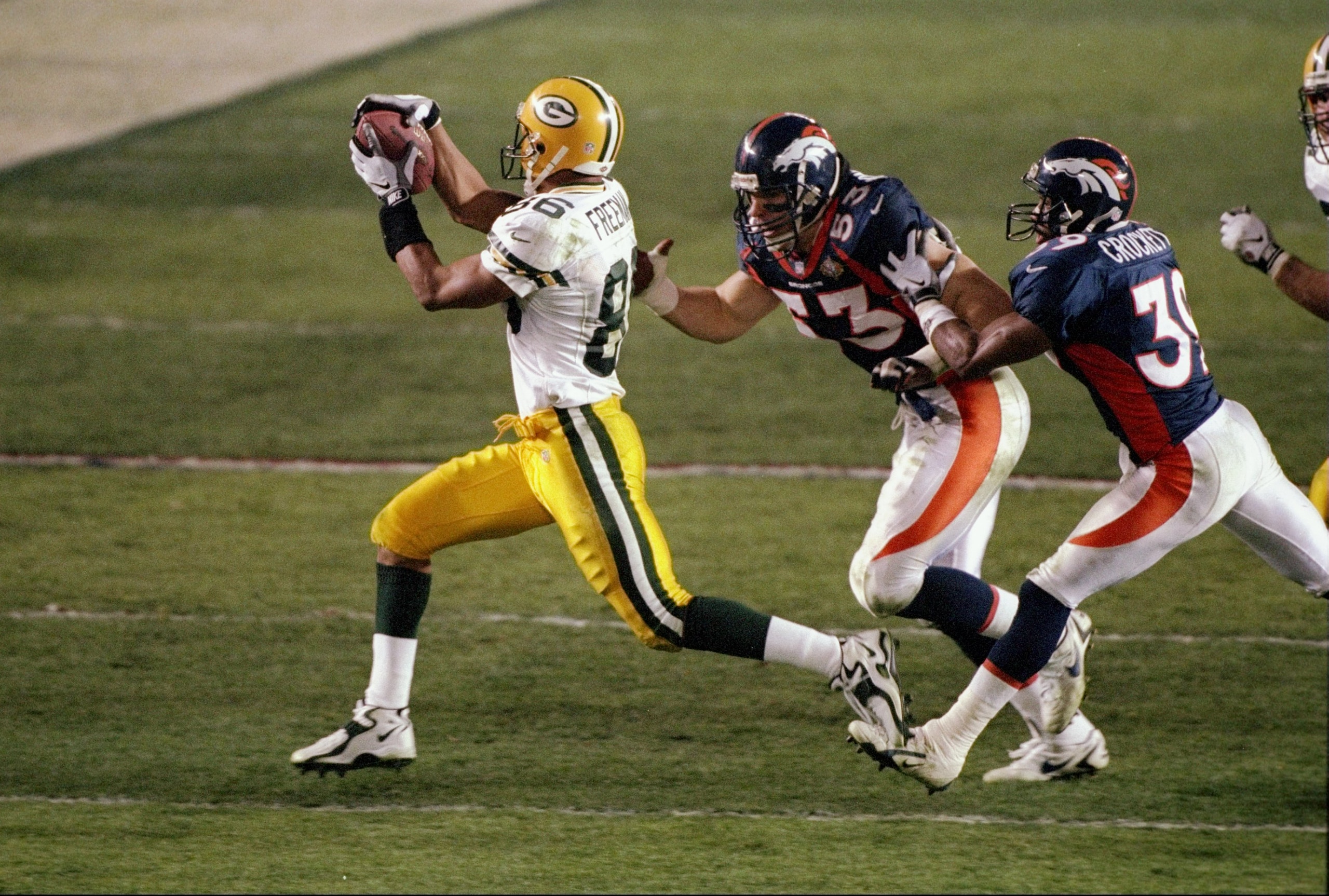 25 Jan 1998:  Wide receiver Antonio Freeman #86 of the Green Bay Packers catches a pass on Bill Romanowski #53 and Ray Crockett #39 of the Denver Broncos during Super Bowl  XXXII at Qualcomm Stadium in San Diego, California.  The Denver Broncos defeated t
