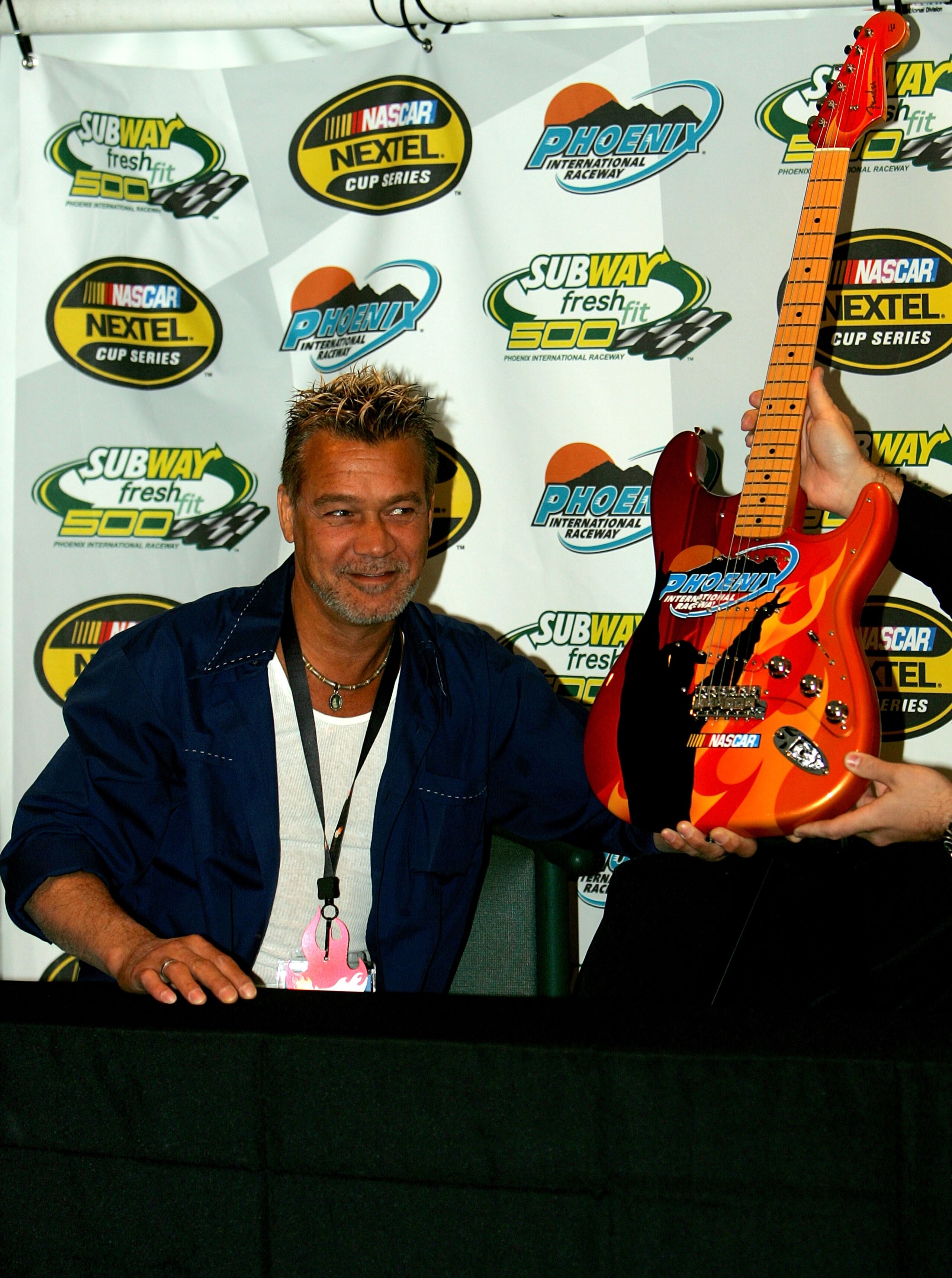 AVONDALE, AZ - APRIL 20:  Musician Eddie Van Halen, who will serve as an honorary race official, poses for pictures with the guitar that will be awarded to the winner of the NASCAR Nextel Cup Series Subway Fresh Fit 500 at Phoenix International Raceway on