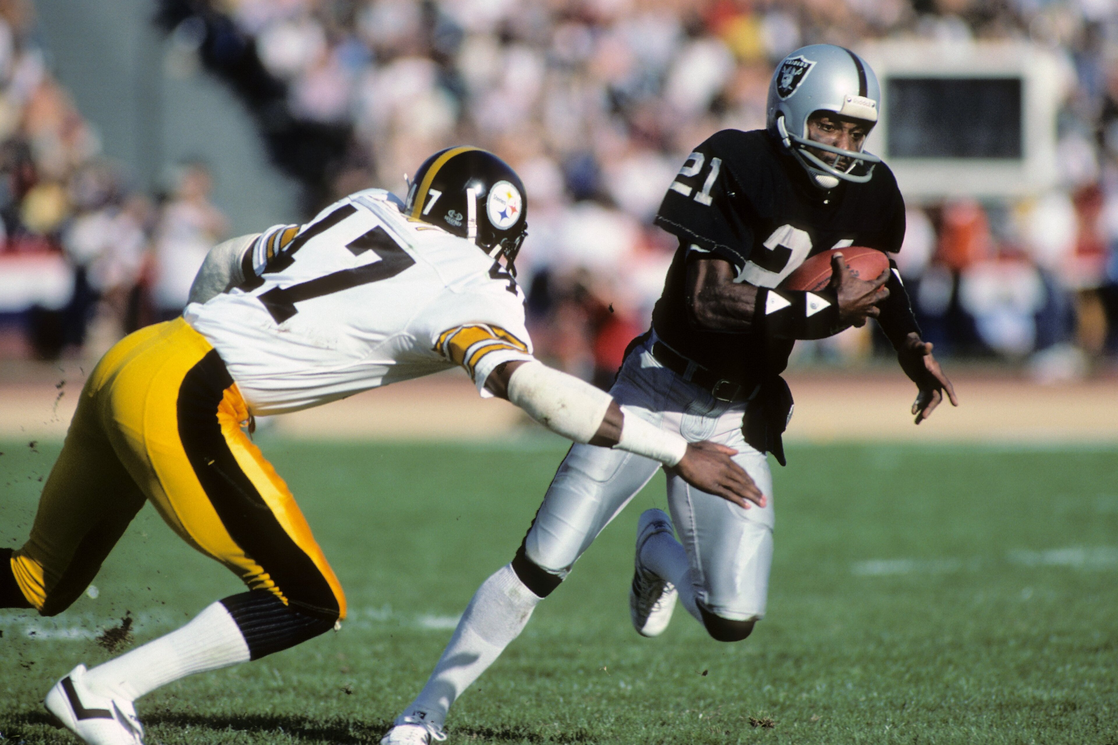 LOS ANGELES, CA - JANUARY 1: Cliff Branch #21 of the Los Angeles Raiders runs the ball against Mel Blount #47 of the Pittsburgh Steelers during the AFC Divisional playoff game at the Los Angeles Memorial Coliseum on January 1, 1984 in Los Angeles, Califo LOS ANGELES, CA - JANUARY 1: Cliff Branch #21 of the Los Angeles Raiders runs the ball against Mel Blount #47 of the Pittsburgh Steelers during the AFC Divisional playoff game at the Los Angeles Memorial Coliseum on January 1, 1984 in Los Angeles, Califo