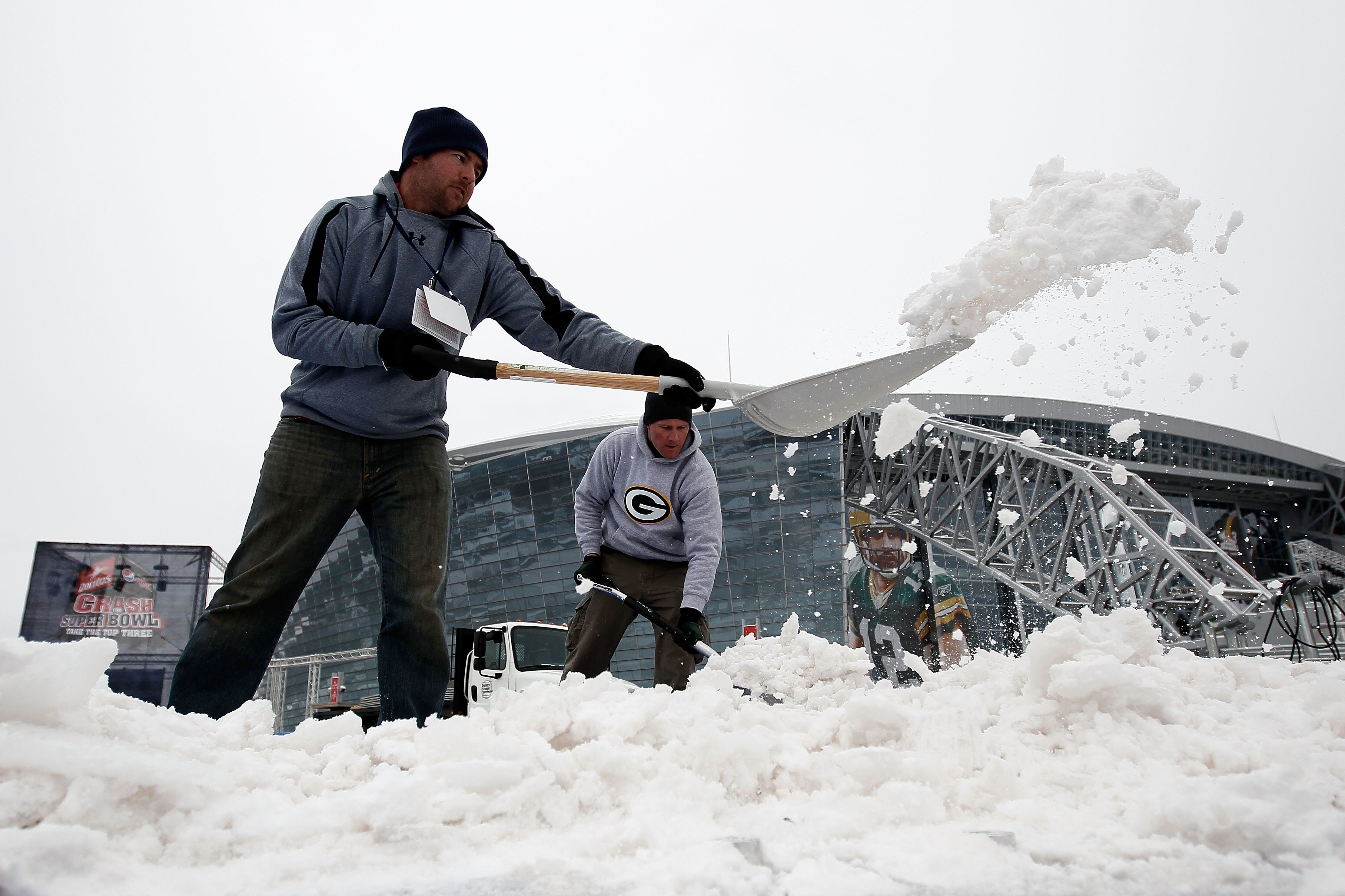ARLINGTON, TX - FEBRUARY 04:  Workers clear snow outside the perimeter of Cowboys Stadium after a snowstorm hit the area February 4, 2011 in Dallas, Texas. More than four inches of snow fell overnight in the North Texas area. The Green Bay Packers will pl