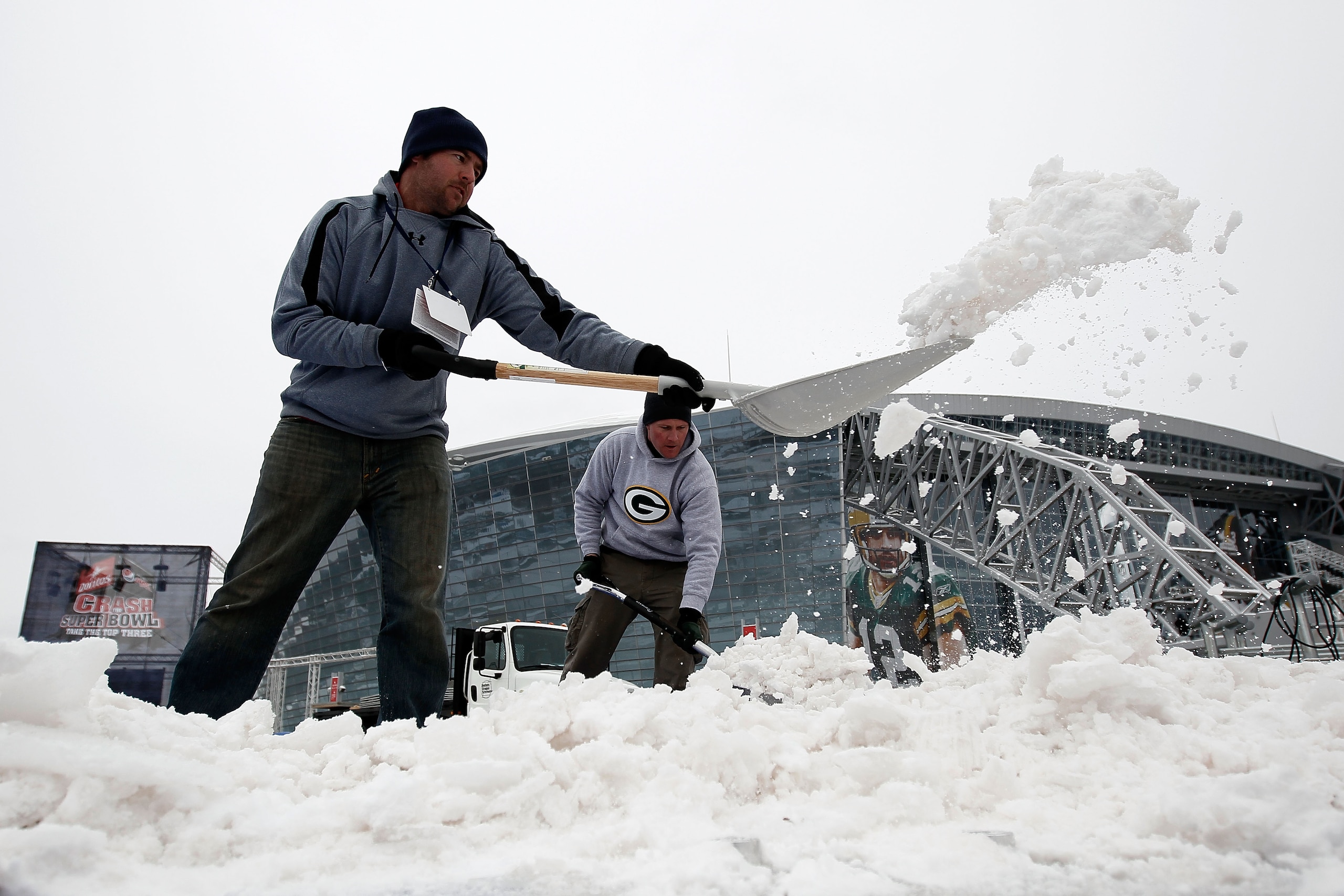 ARLINGTON, TX - FEBRUARY 04:  Workers clear snow outside the perimeter of Cowboys Stadium after a snowstorm hit the area February 4, 2011 in Dallas, Texas. More than four inches of snow fell overnight in the North Texas area. The Green Bay Packers will pl