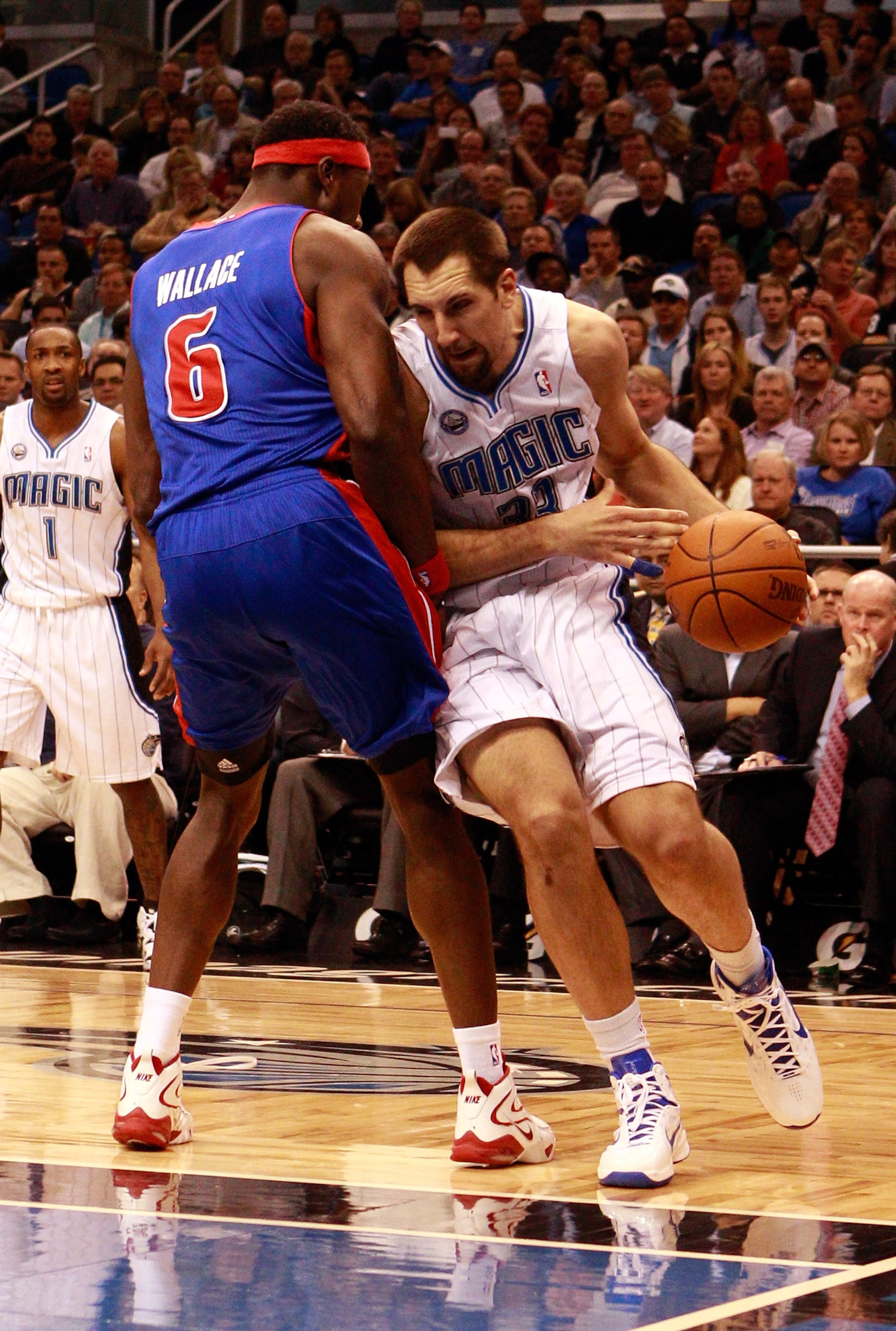 ORLANDO, FL - JANUARY 24:   Ryan Anderson #33 of the Orlando Magic drives against Ben Wallace #6 of the Detroit Pistons during the game at Amway Arena on January 24, 2011 in Orlando, Florida.  NOTE TO USER: User expressly acknowledges and agrees that, by