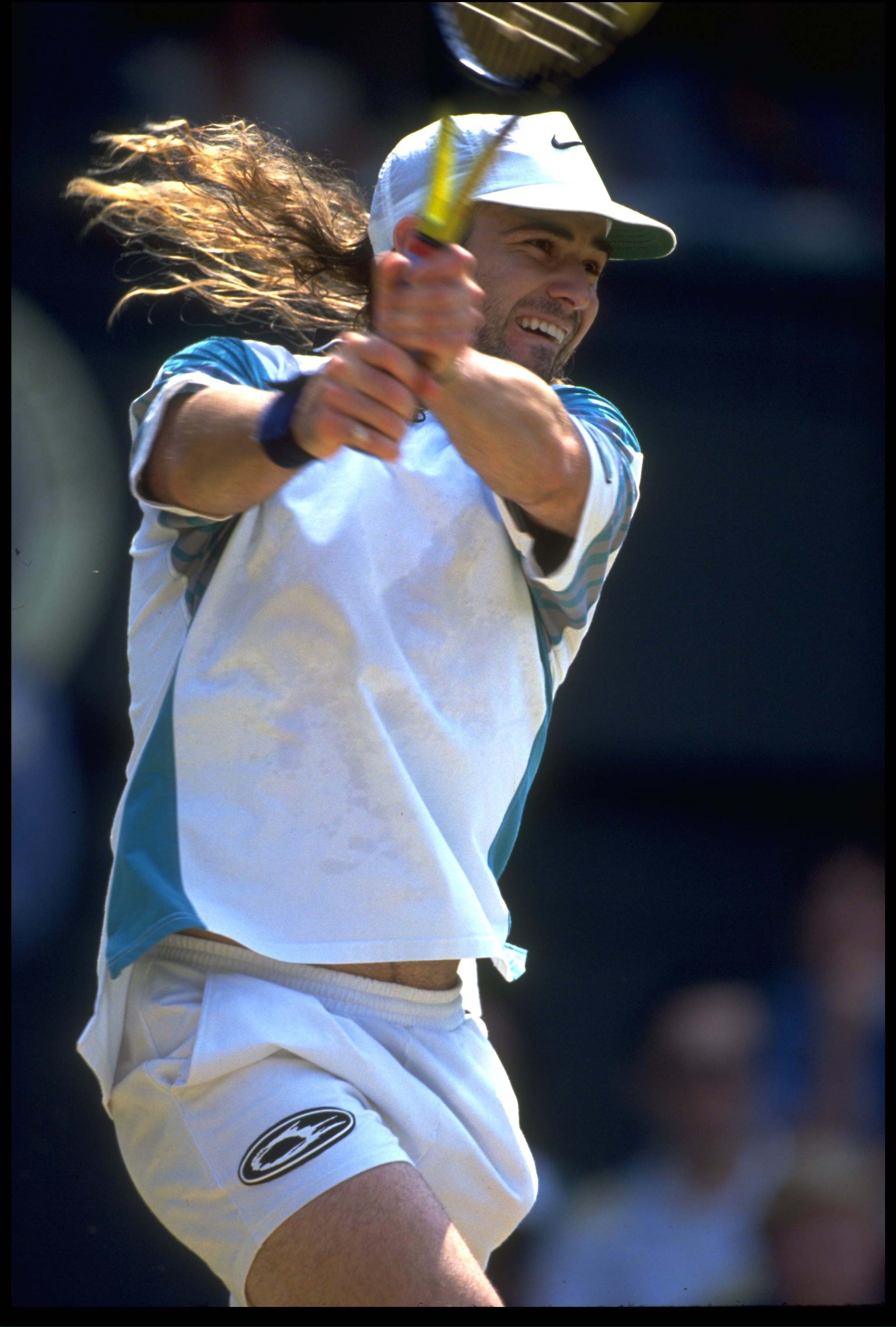 29 JUN 1993:  ANDRE AGASSI OF THE UNITED STATES PLAYS A TWO-HANDED BACKHAND DURING HIS QUARTER-FINAL MATCH AGAINST PETE SAMPRAS OF THE USA AT THE 1993 WIMBLEDON TENNIS CHAMPIONSHIPS. SAMPRAS WON THE MATCH AND PROCEEDED TO THE FINAL.
