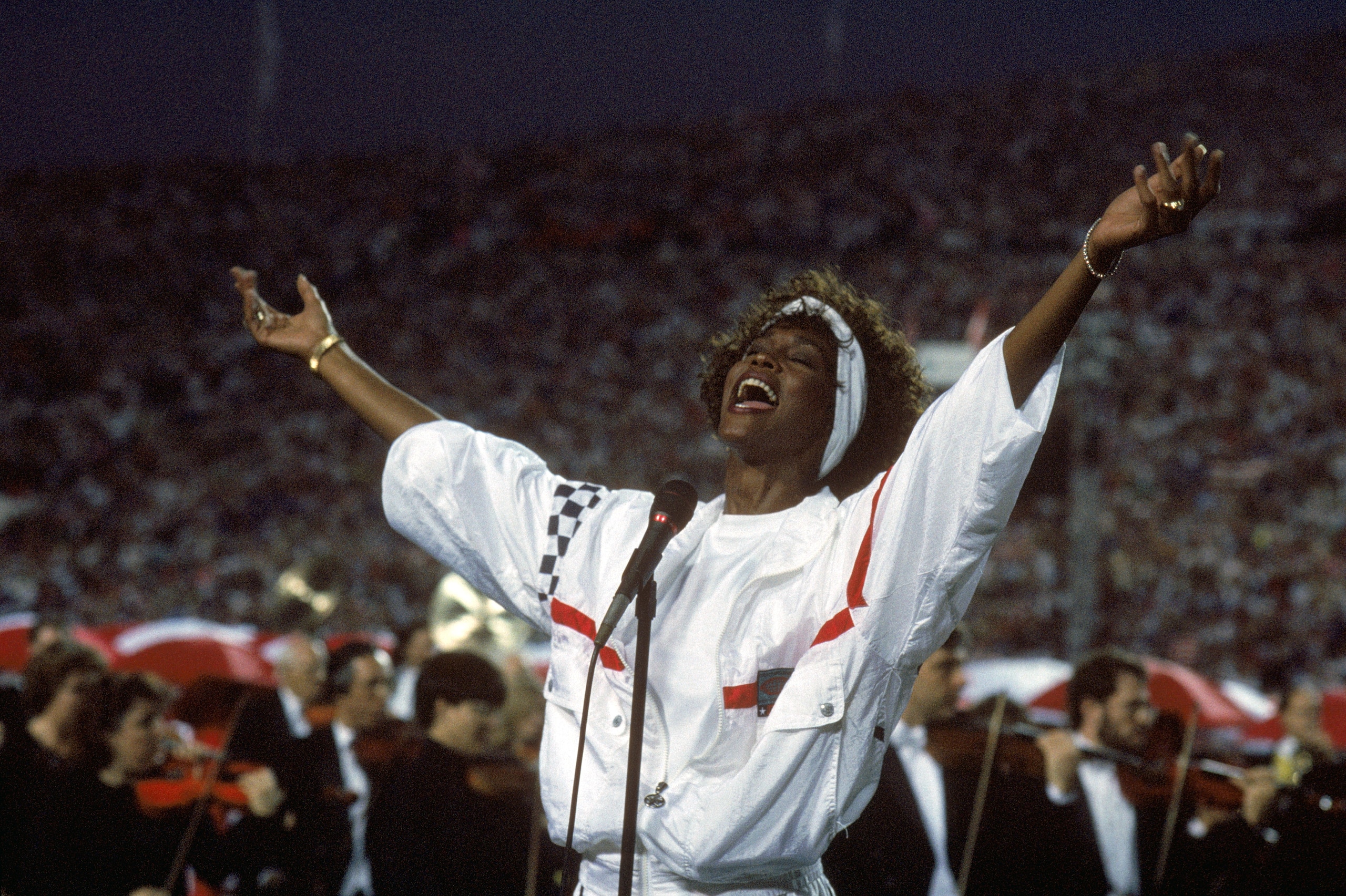 TAMPA, FL - JANUARY 27:  Whitney Houston sings the National Anthem before a game with the New York Giants taking on the Buffalo Bills prior to Super Bowl XXV at Tampa Stadium on January 27, 1991 in Tampa, Florida. The Giants won 20-19. (Photo by George Ro