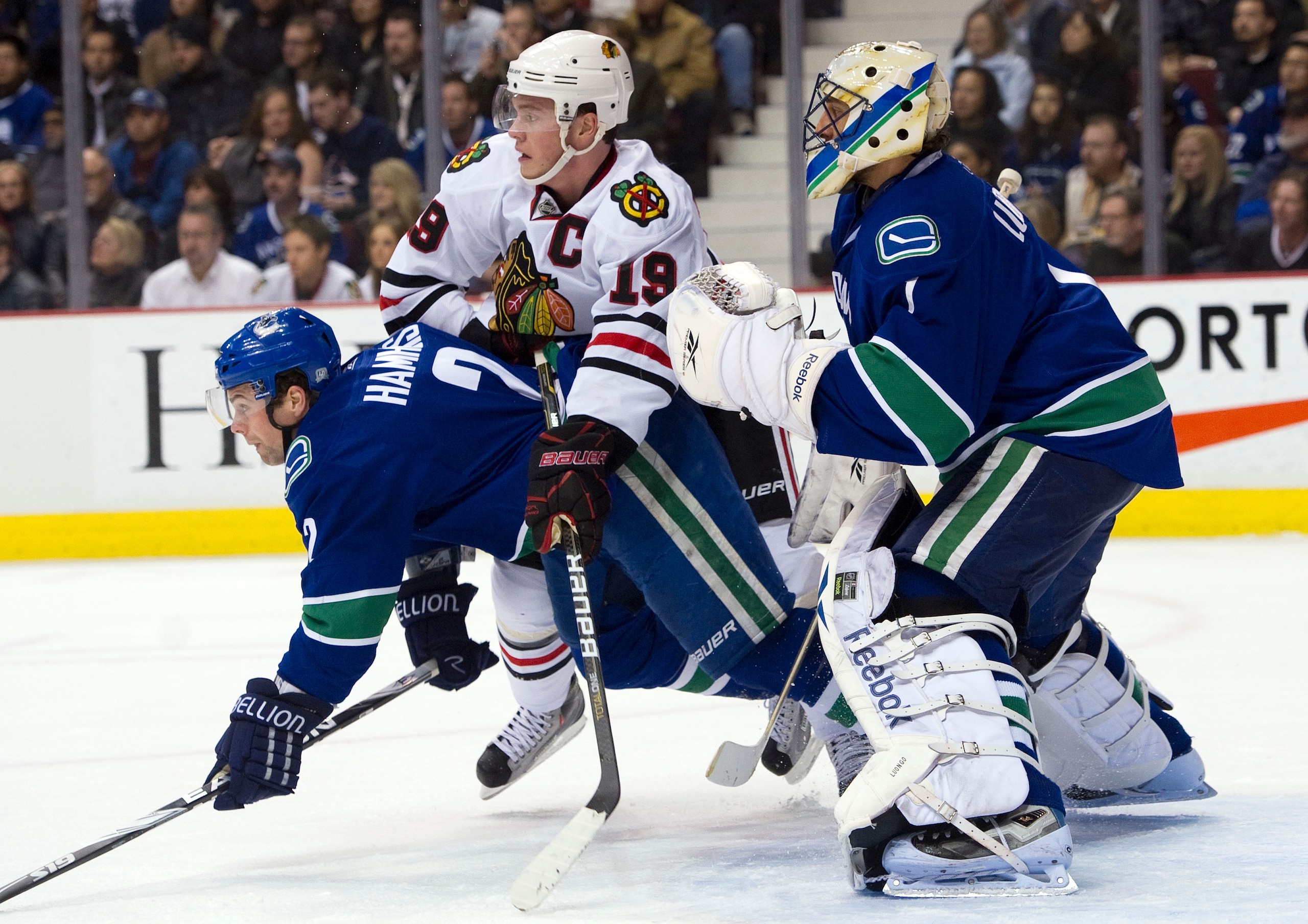 VANCOUVER, CANADA - JANUARY 4: Jonathan Toews #19 of the Chicago Blackhawks battles with Dan Hamhuis #2 of the Vancouver Canucks for position in front of goalie Roberto Luongo #1 during the first period in NHL action on February 04, 2011 at Rogers Arena i VANCOUVER, CANADA - JANUARY 4: Jonathan Toews #19 of the Chicago Blackhawks battles with Dan Hamhuis #2 of the Vancouver Canucks for position in front of goalie Roberto Luongo #1 during the first period in NHL action on February 04, 2011 at Rogers Arena i