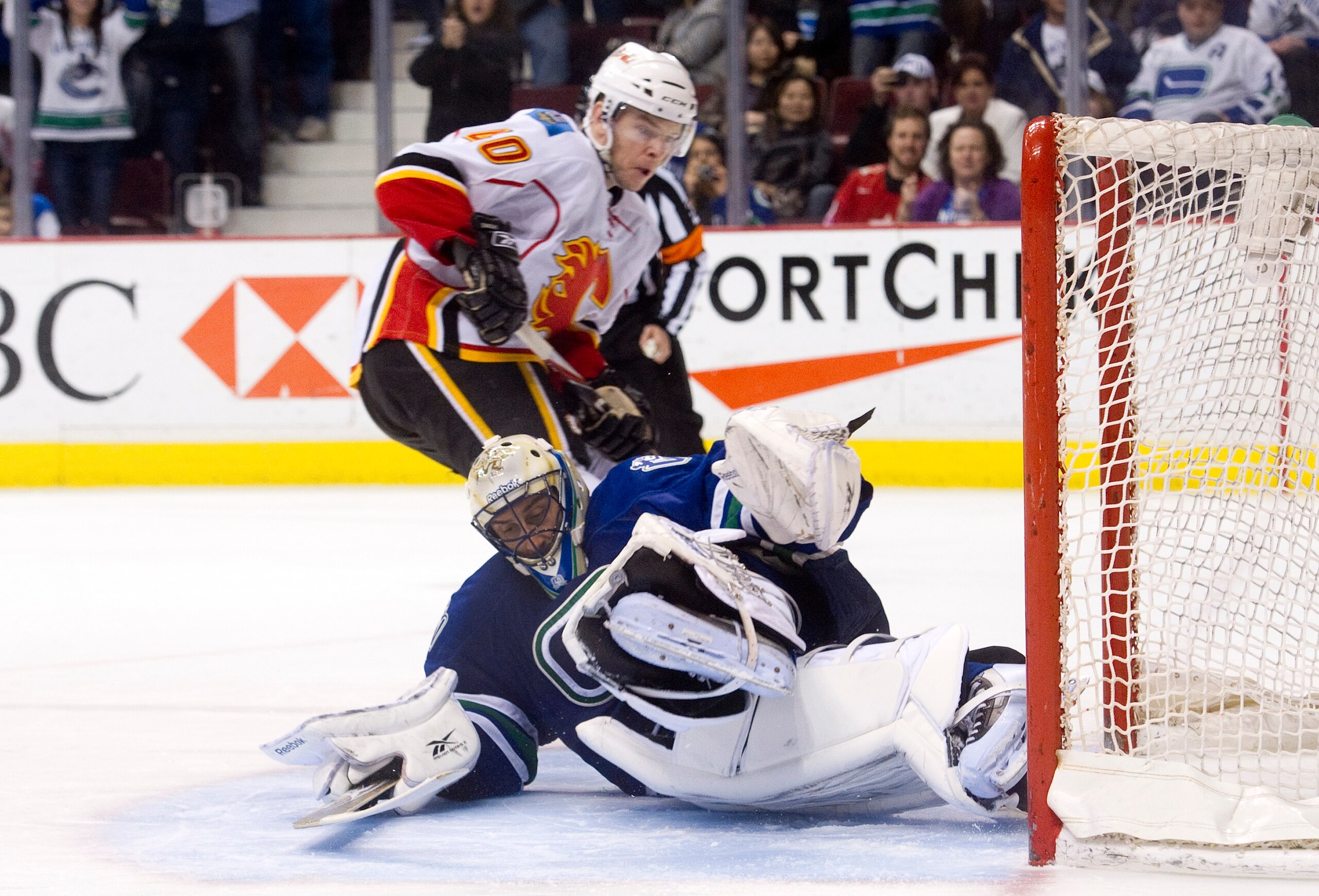 VANCOUVER, CANADA - JANUARY 22: Goalie Roberto Luongo #1 of the Vancouver Canucks stops Alex Tanguay #40 of the Calgary Flames but slides into the net during the shootout in NHL action on January 22, 2011 at Rogers Arena in Vancouver, British Columbia, Ca VANCOUVER, CANADA - JANUARY 22: Goalie Roberto Luongo #1 of the Vancouver Canucks stops Alex Tanguay #40 of the Calgary Flames but slides into the net during the shootout in NHL action on January 22, 2011 at Rogers Arena in Vancouver, British Columbia, Ca