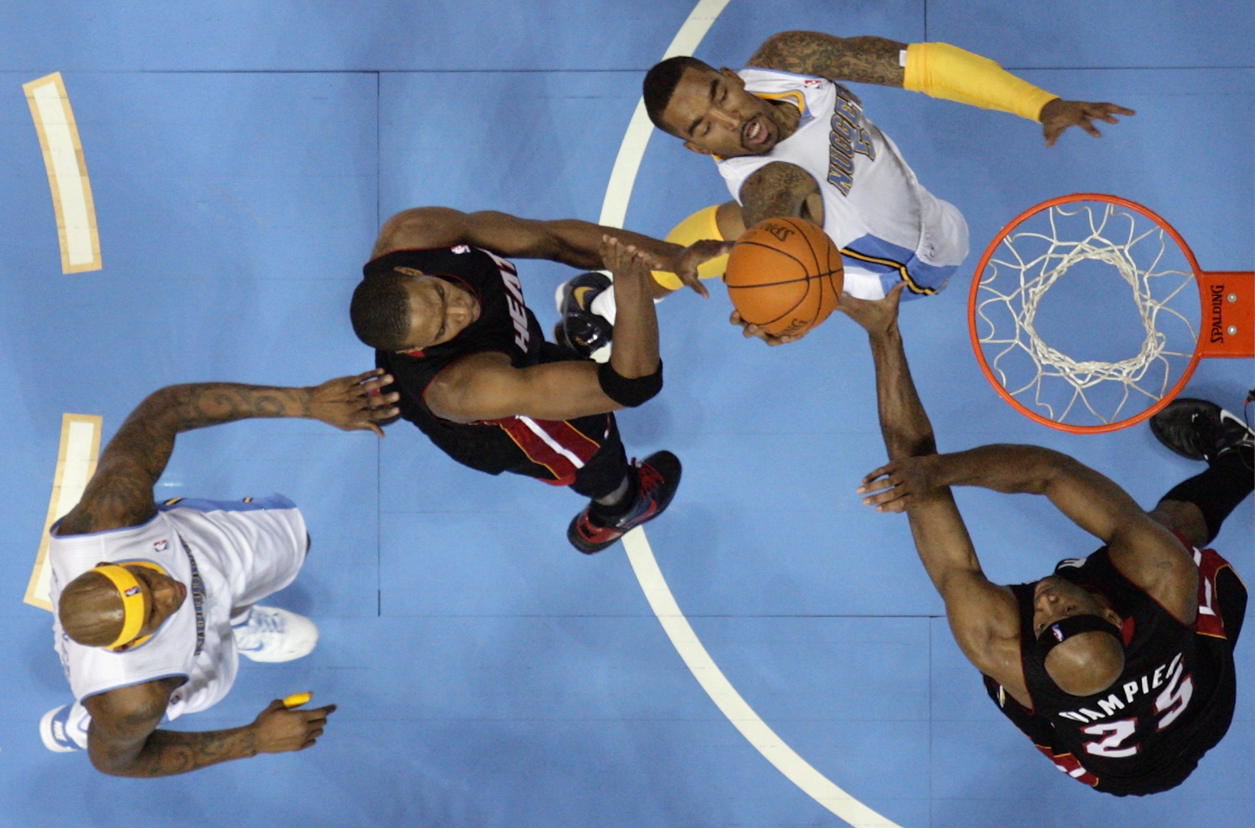 DENVER, CO - JANUARY 13:  J.R. Smith #5 of the Denver Nuggets puts up a shot between Chris Bosh #1 and Eric Dampier #25 of the Miami Heat as Al Harrington #7 of the Nuggets follows the play at the Pepsi Center on January 13, 2011 in Denver, Colorado. The