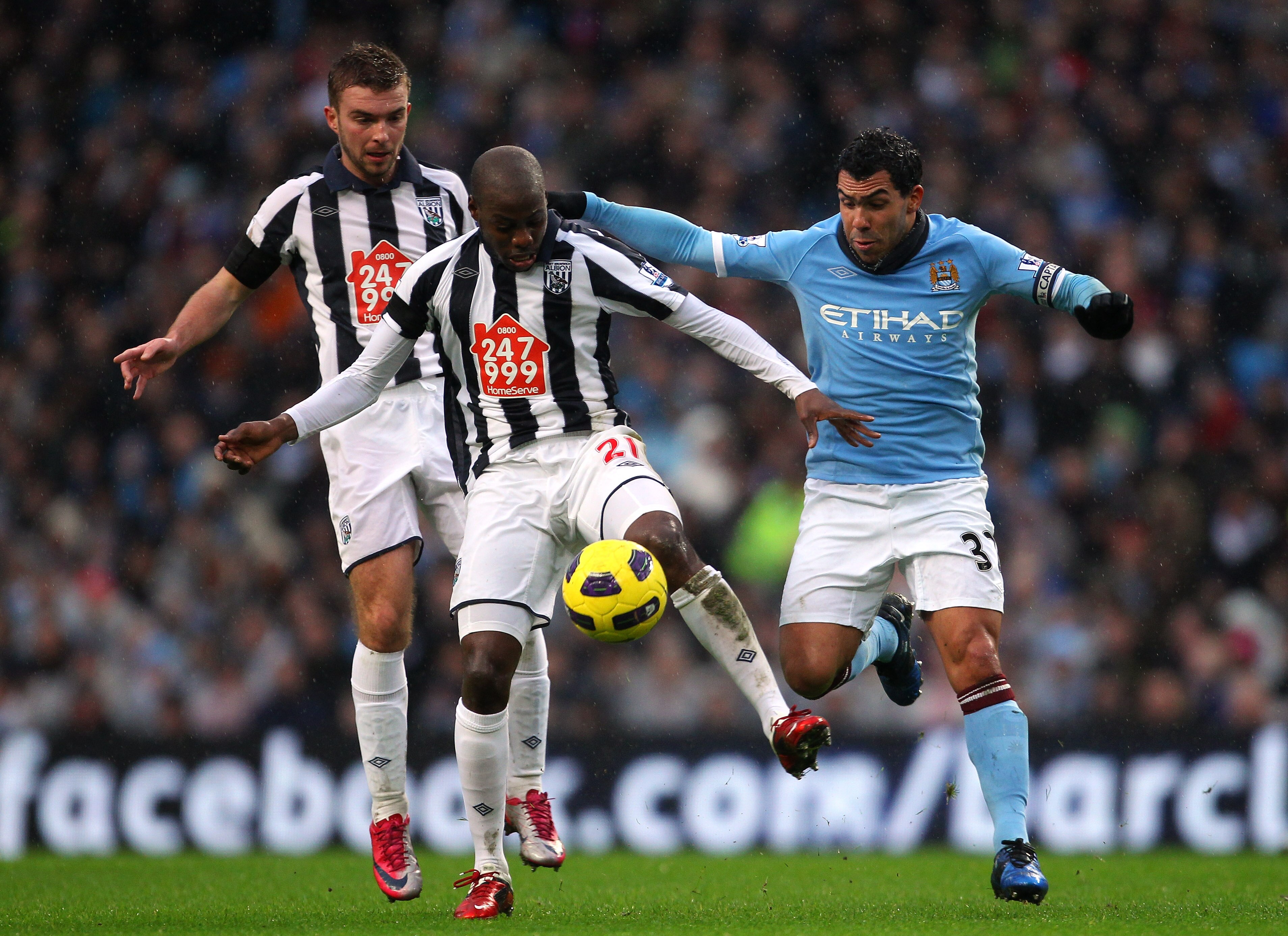 MANCHESTER, ENGLAND - FEBRUARY 05:  Carlos Tevez of Manchester City puts Youssuf Mulumbu of West Bromwich Albion under pressure during the Barclays Premier League match between Manchester City and West Bromwich Albion at the City of Manchester Stadium on