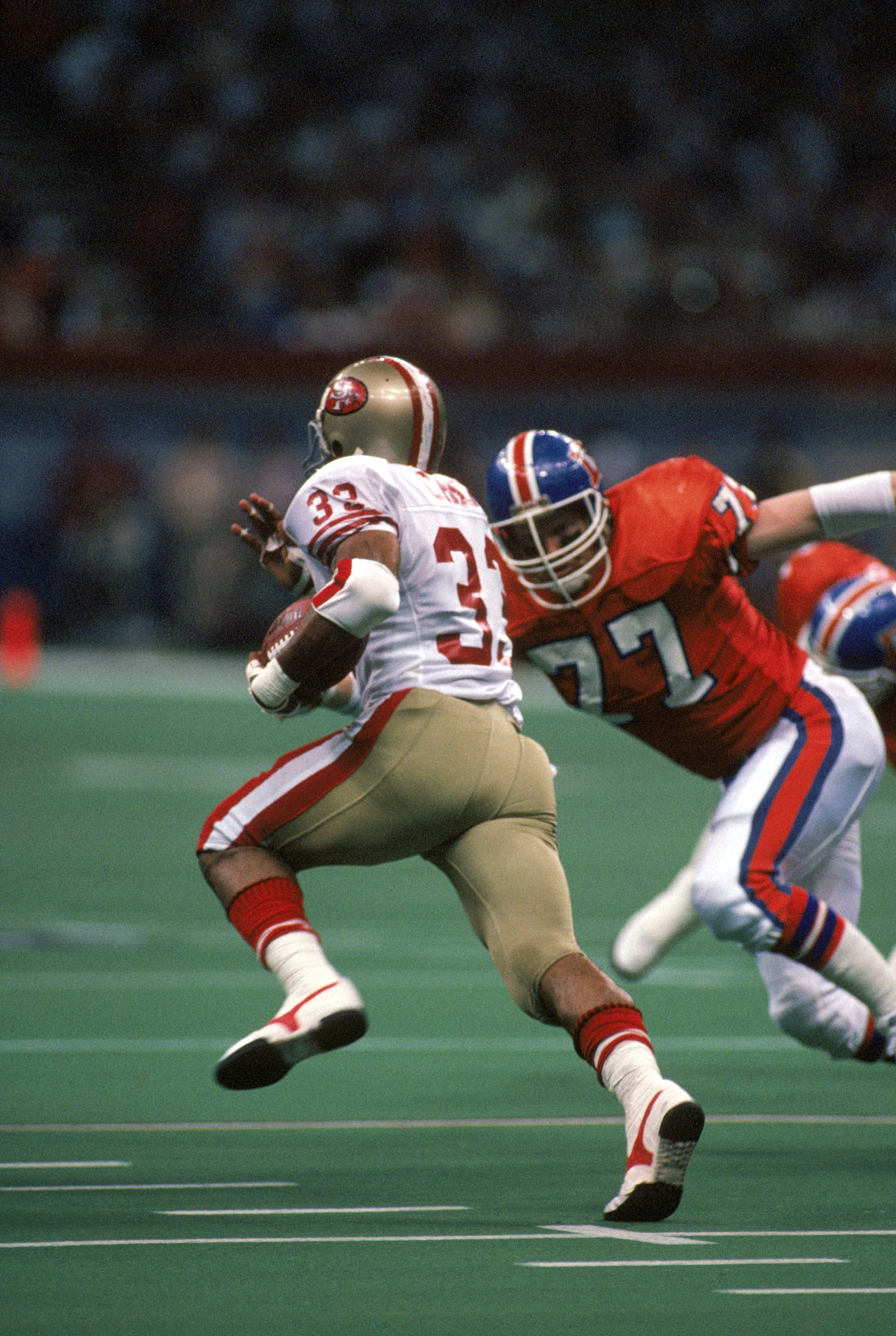 NEW ORLEANS - JANUARY 28:  Linebacker Karl Mecklenburg #77 of the Denver Broncos closes in on running back Roger Craig #33 of the San Francisco 49ers during Super Bowl XXIV at the Louisiana Superdome on January 28, 1990 in New Orleans, Louisiana.  The 49e