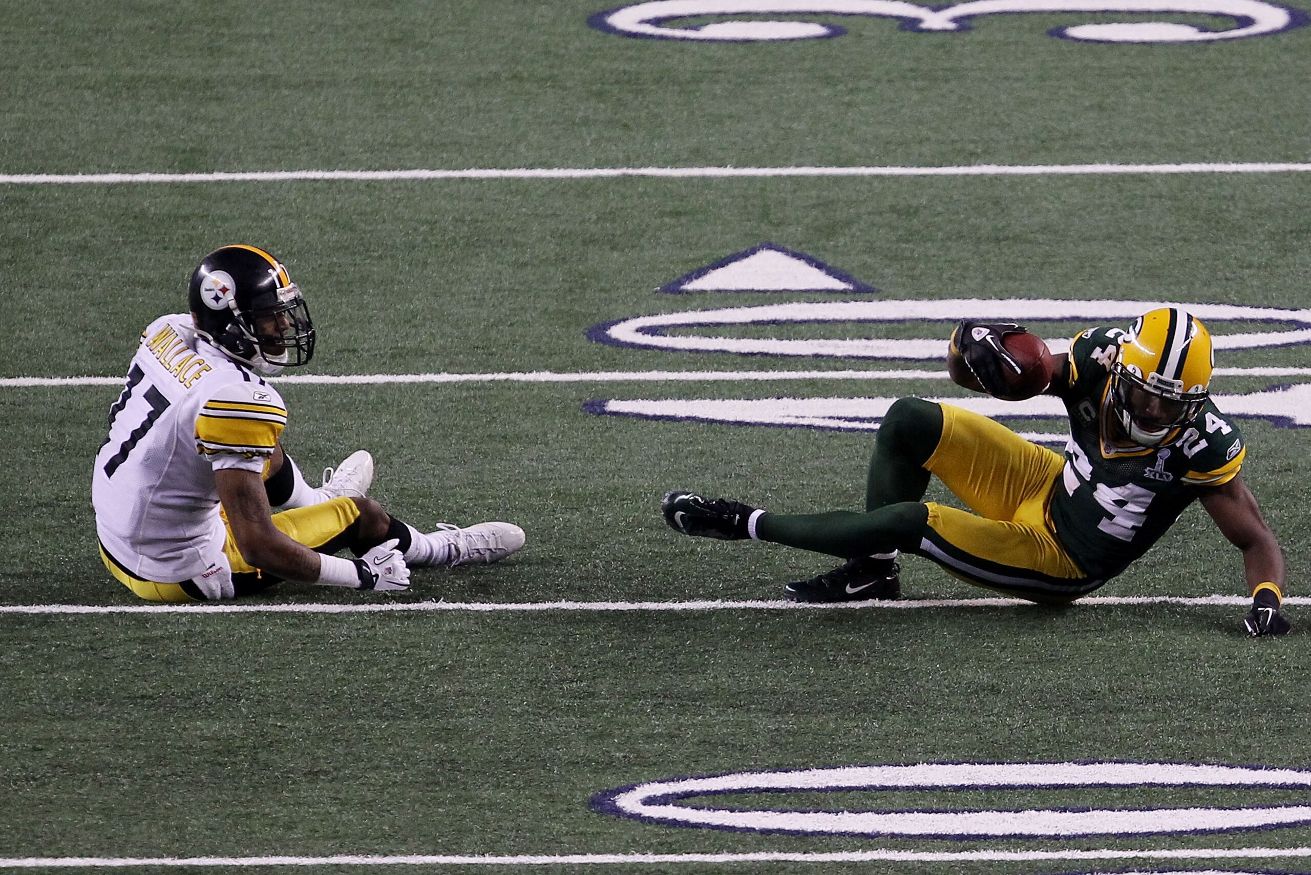 ARLINGTON, TX - FEBRUARY 06:  Jarrett Bush #24 of the Green Bay Packers intercepts a pass against Mike Wallace #17 of the Pittsburgh Steelers in the fourt quarter during Super Bowl XLV at Cowboys Stadium on February 6, 2011 in Arlington, Texas.  (Photo by