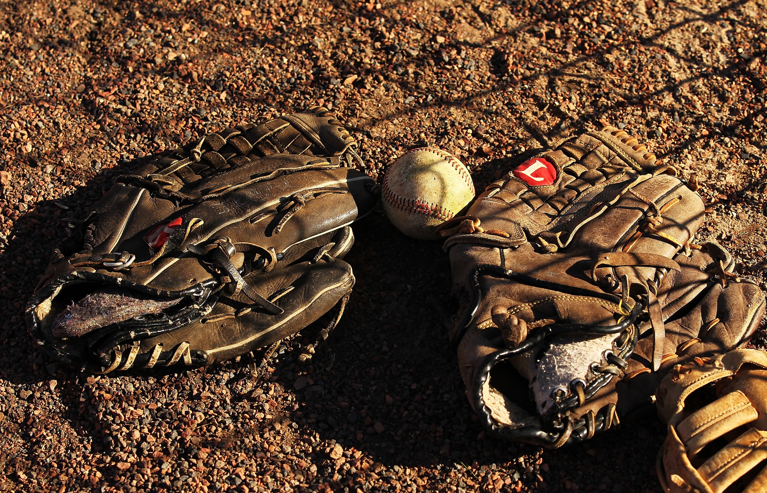 KISSIMMEE, FL - JANUARY 28:  Baseball gloves and a baseball lie in the dirt during the Jim Evans Academy of Professional Umpiring on January 28, 2011 at the Houston Astros Spring Training Complex  in Kissimmee, Florida.  Jim Evans was a Major League Umpir