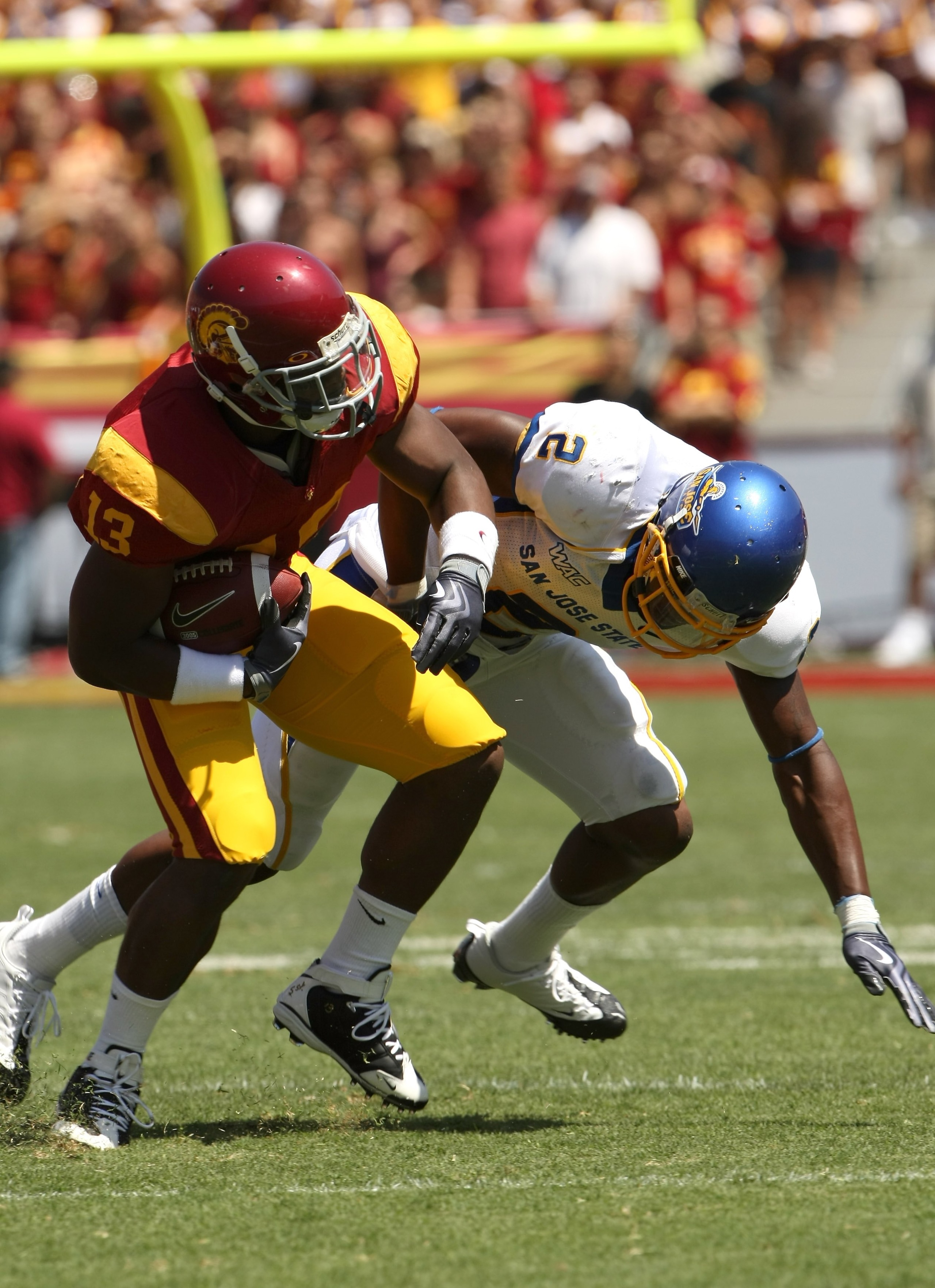 LOS ANGELES, CA - SEPTEMBER 05:  Running back Stafon Johnson #13 of the USC Trojans runs into safety Duke Ihenacho #2 of the San Jose State Spartans on September 5, 2009 at the Los Angeles Coliseum in Los Angeles, California.  USC won 56-3.  (Photo by Ste