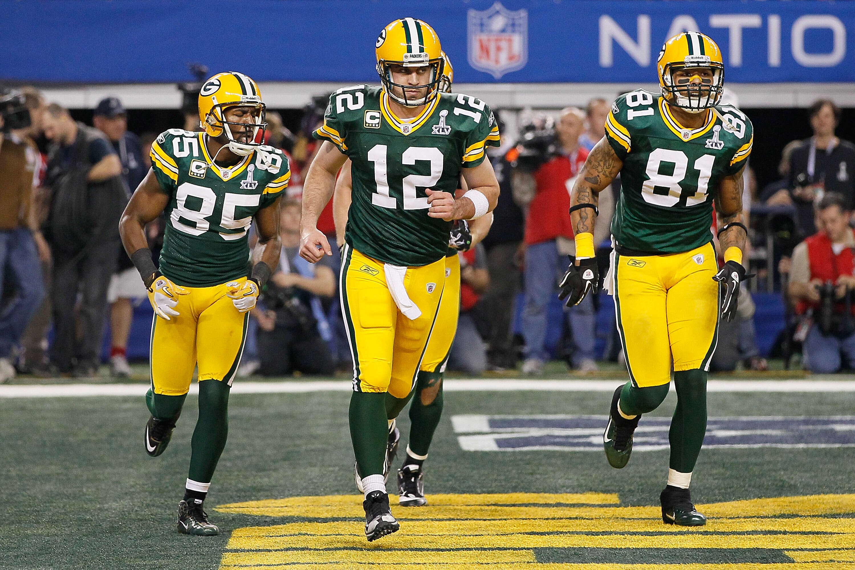 ARLINGTON, TX - FEBRUARY 06: Aaron Rodgers #12 of the Green Bay Packers celebrates with teammates Greg Jennings #85 and Andrew Quarless #81 after an 8 yard touchdown to Jennings in the fourth quarter against the Pittsburgh Steelers during Super Bowl XLV a