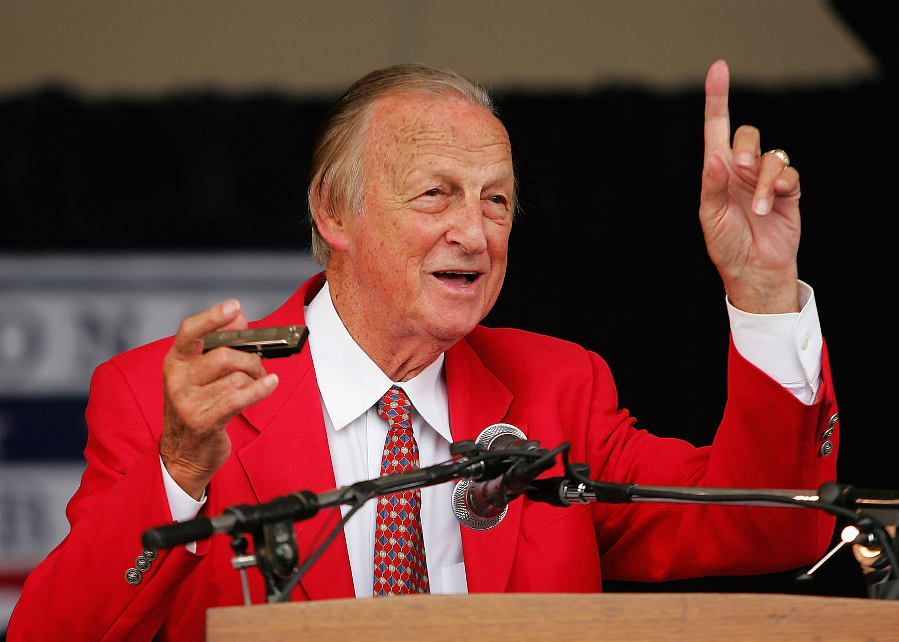 COOPERSTOWN, NY - JULY 31:  Stan Musial gets his harmonica ready to sing 'Take Me Out to the Ball Game' during the Baseball Hall of Fame induction ceremony on July 31, 2005 at the Clark Sports Complex in Cooperstown, New York.  (Photo by Ezra Shaw/Getty I
