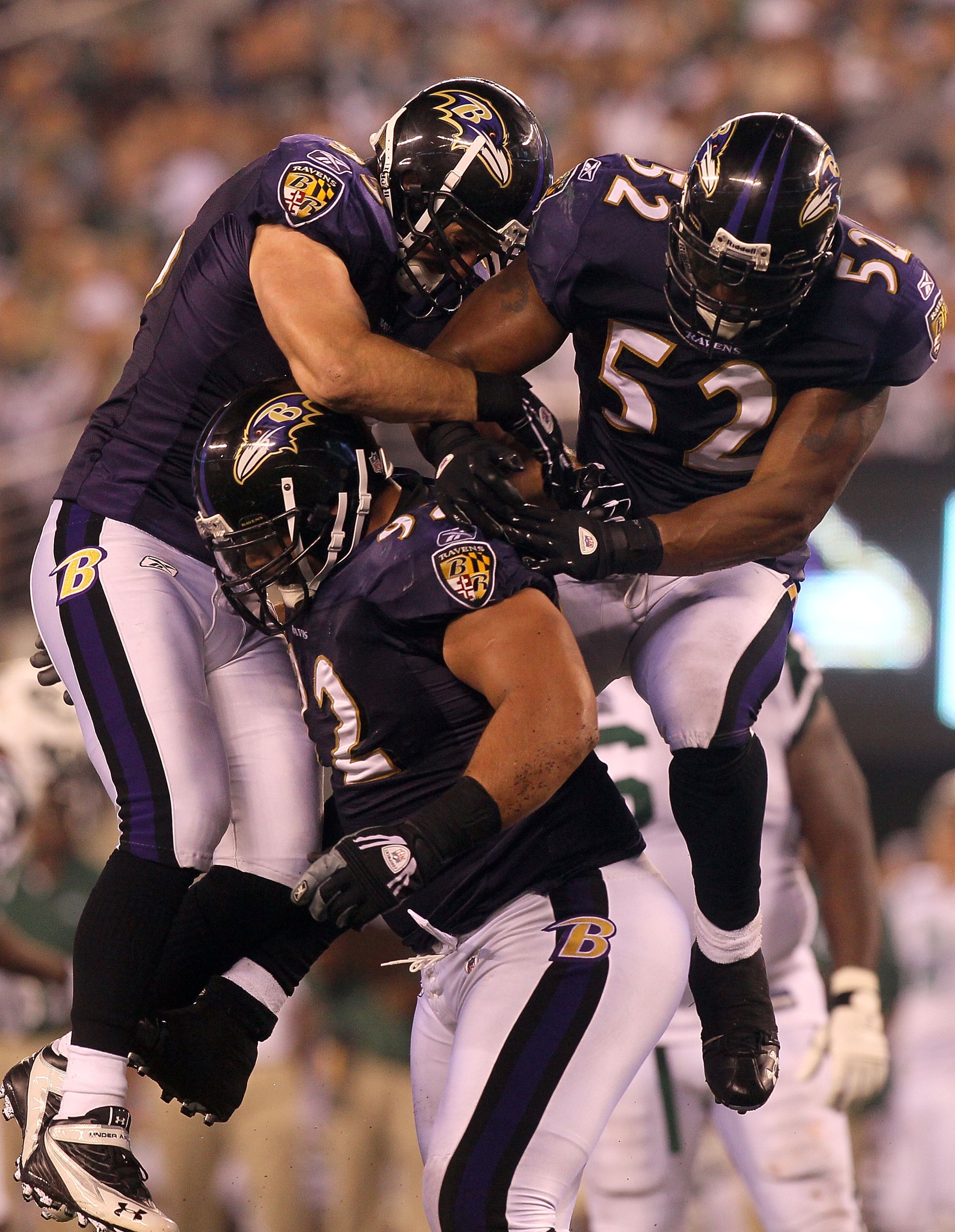 EAST RUTHERFORD, NJ - SEPTEMBER 13:  Ray Lewis #52 and Jarret Johnson #95 jump on Haloti Ngata #92 of the Baltimore Ravens after a sack in the fourth quarter against the New York Jets during their home opener at the New Meadowlands Stadium on September 13