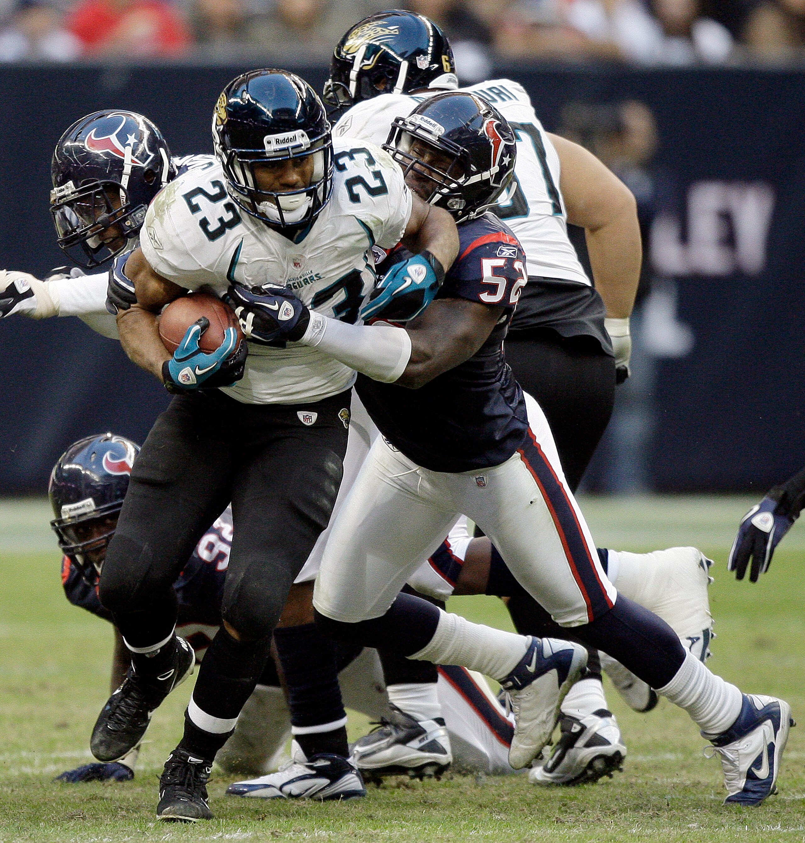 HOUSTON - JANUARY 02:  Running back Rashad Jennings #23 of the Jacksonville Jaguars is tackled by Xavier Adibi #52 of the Houston Texans at Reliant Stadium on January 2, 2011 in Houston, Texas.  (Photo by Bob Levey/Getty Images)