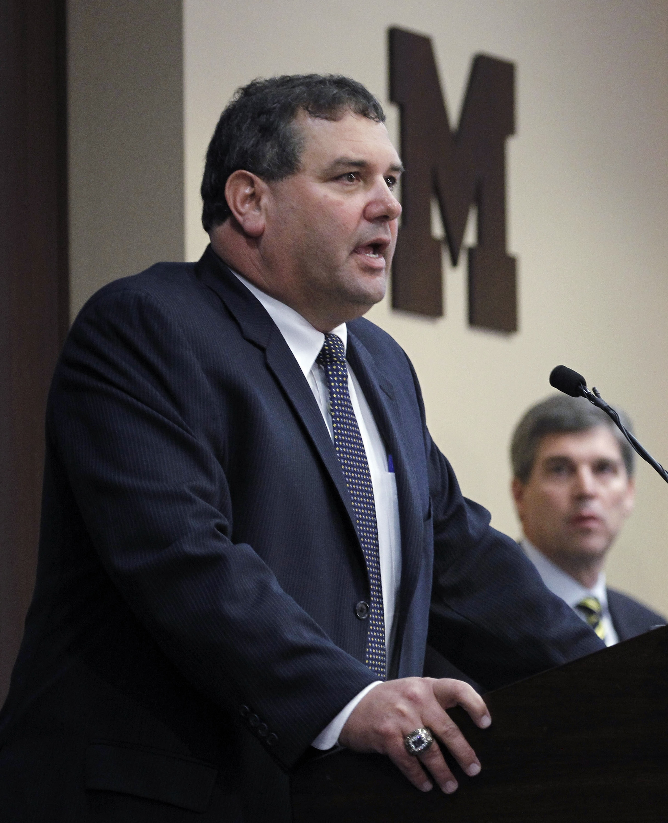 ANN ARBOR, MI - JANUARY 12:  New University of Michigan head football coach Brady Hoke (L) speaks to the media as, Athletic Director Dave Brandon looks on, after introducing Hoke as the nineteenth Michigan head football coach in Michigan history at the Ju