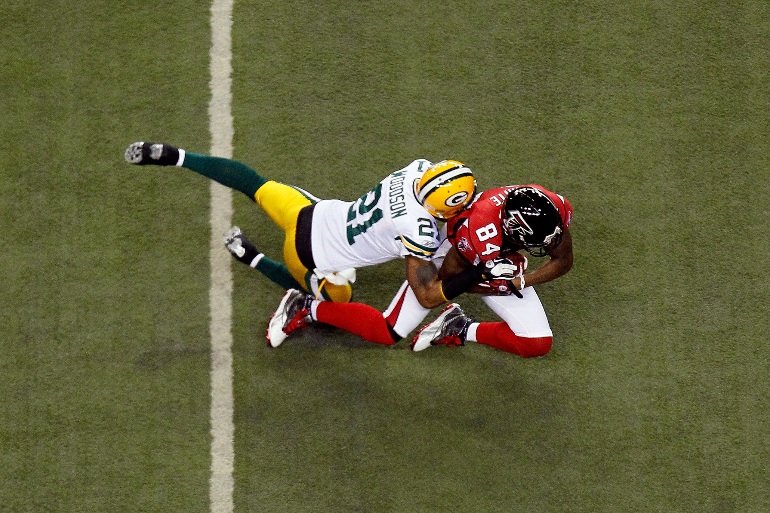 ATLANTA, GA - JANUARY 15:  Roddy White #84 of the Atlanta Falcons is tackled by Charles Woodson #21 of the Green Bay Packers during their 2011 NFC divisional playoff game at Georgia Dome on January 15, 2011 in Atlanta, Georgia.  (Photo by Kevin C. Cox/Get