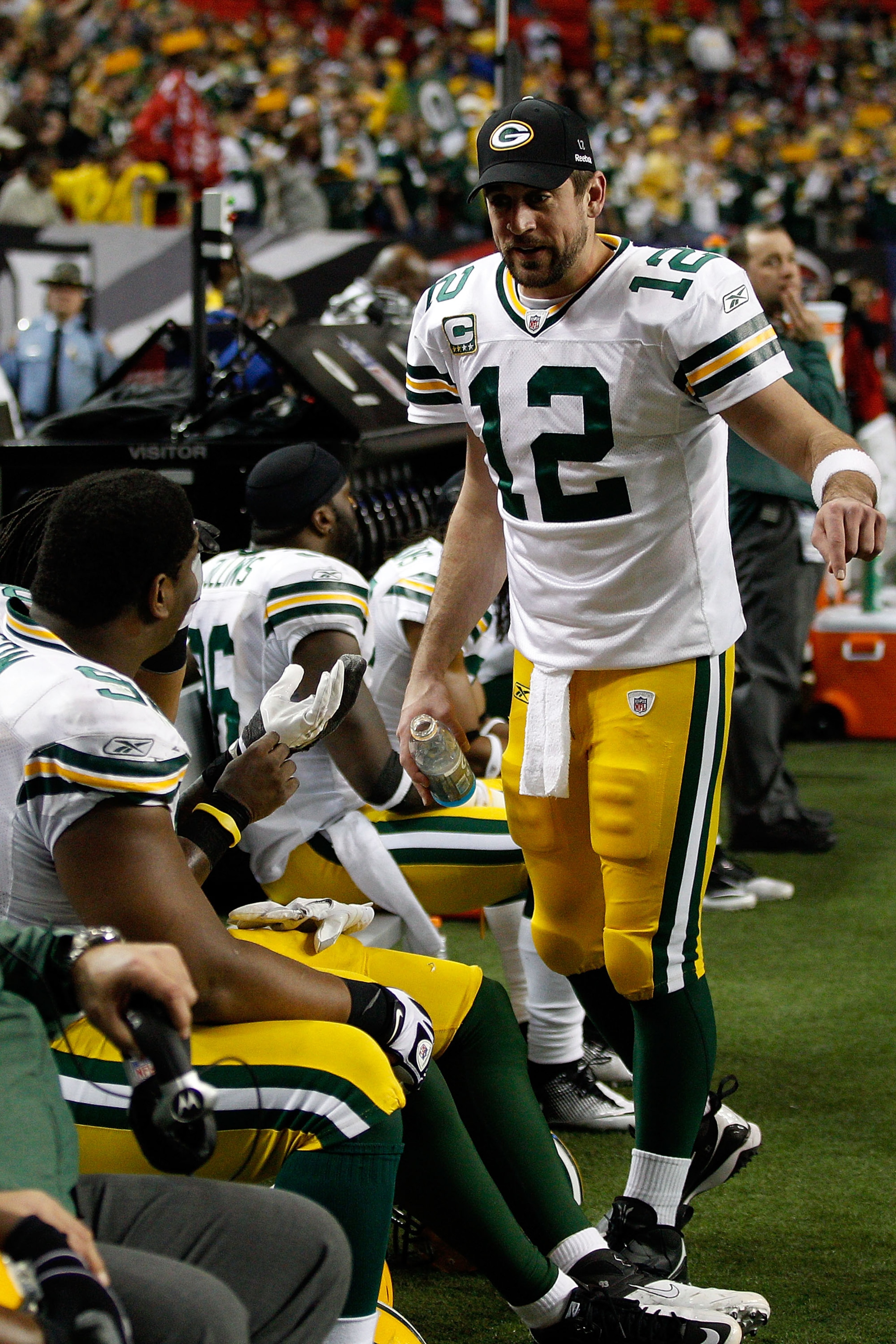 ATLANTA, GA - JANUARY 15:  Quarterback Aaron Rodgers #12 of the Green Bay Packers talks with teammates on the bench against the Atlanta Falcons during their 2011 NFC divisional playoff game at Georgia Dome on January 15, 2011 in Atlanta, Georgia.  (Photo