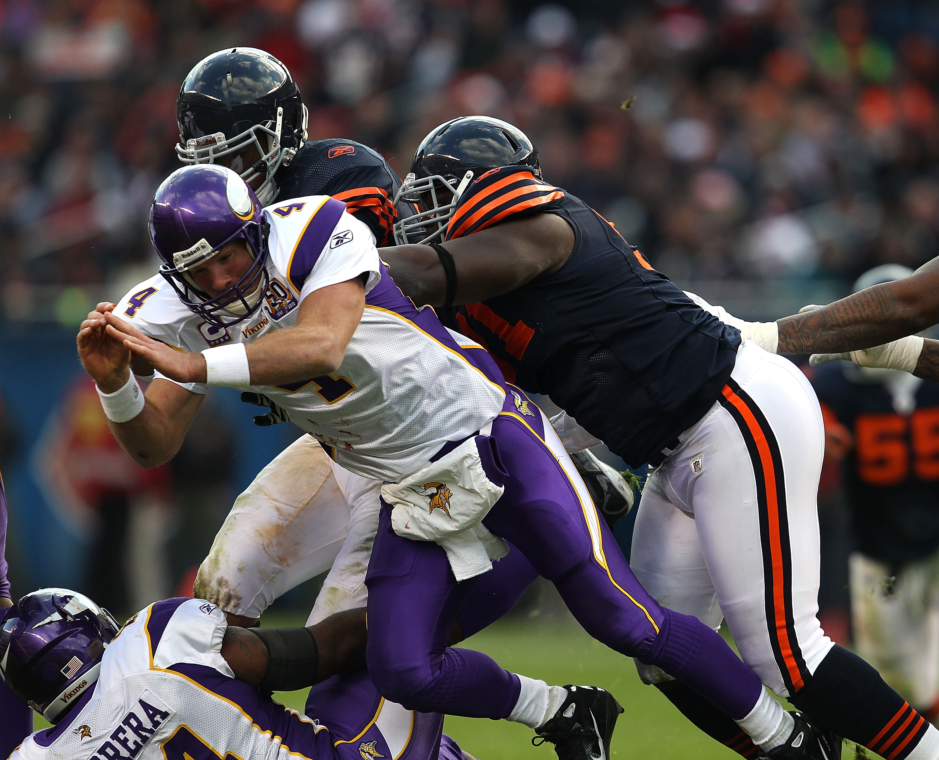 CHICAGO - NOVEMBER 14: Julius Peppers #90 (L) and Israel Idonije #71 of the Chicago Bears knock down Brett Favre #4 of the Minnesota Vikings after a pass at Soldier Field on November 14, 2010 in Chicago, Illinois. The Bears defeated the Vikings 27-13. (Ph