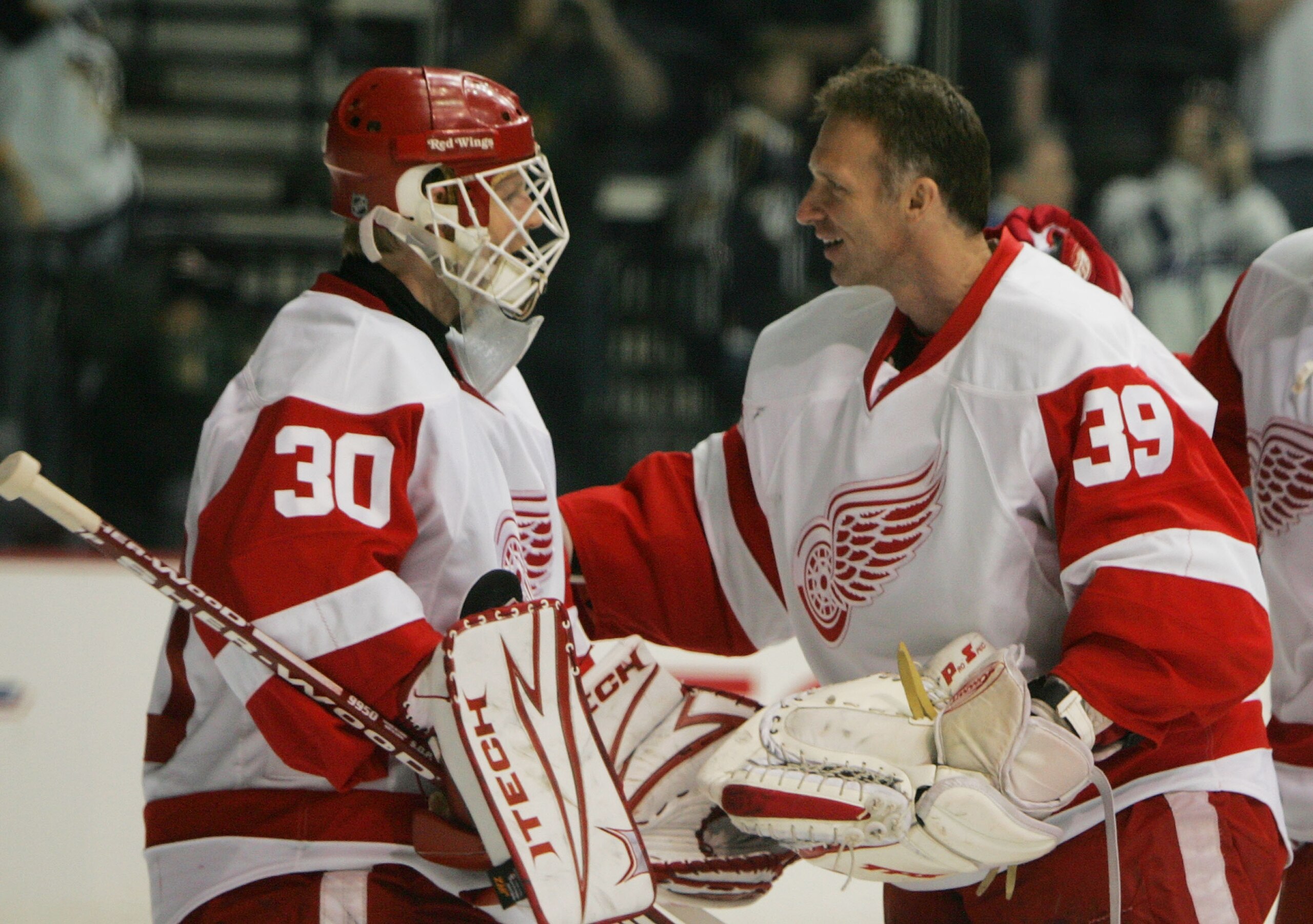NASHVILLE, TN - APRIL 20: Chris Osgood #30 of the Detroit Red Wings is congratulated by Dominik Hasek #39 on Osgood's shut out victory over the Nashville Predators on April 20, 2008 during game six of the Western Conference Quarterfinals of the 2008 NHL S