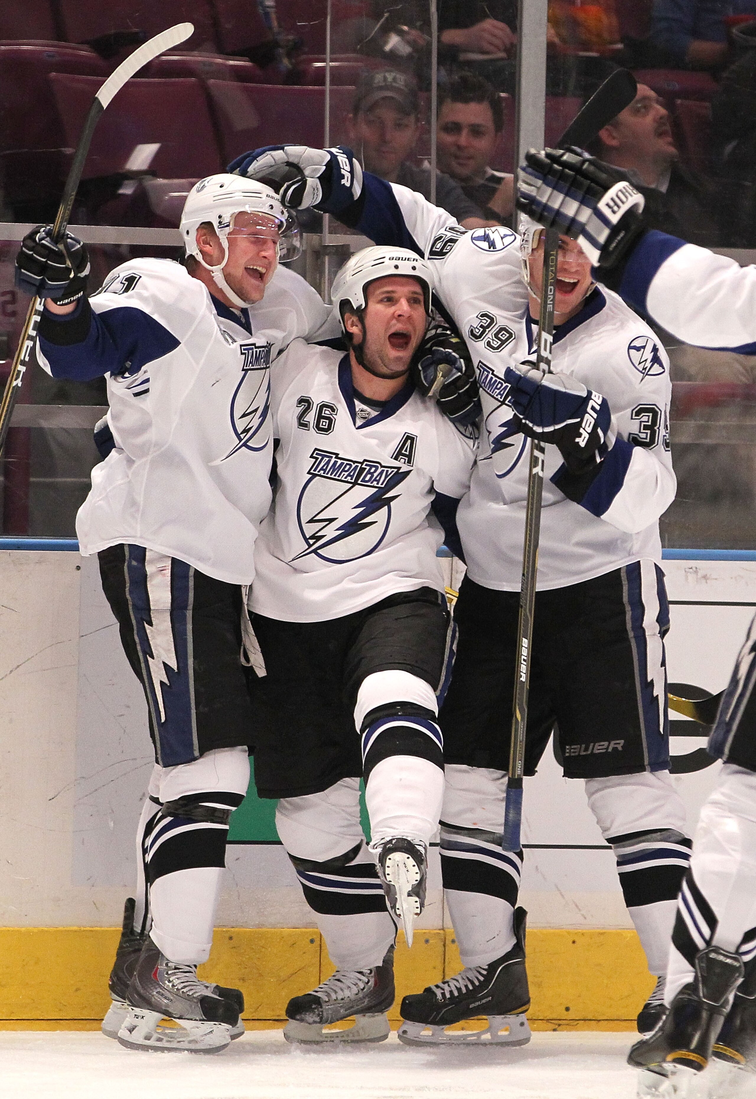 NEW YORK, NY - DECEMBER 23: Steven Stamkos #91, Martin St. Louis #26, and Mike Lundin #39 of the Tampa Bay Lightning celebrate a goal by St. Louis during an NHL hockey game against the New York Rangers at Madison Square Garden on December 23, 2010 in New