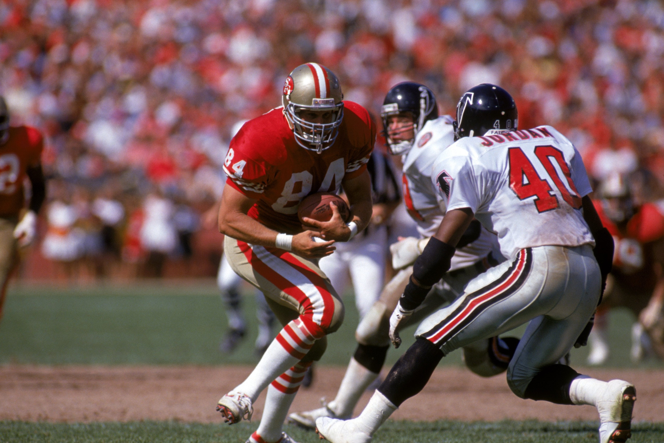 SAN FRANCISCO - SEPTEMBER 23:  Tight end Brent Jones #84 of the San Francisco 49ers runs for yards against Atlanta Falcons safety Brian Jordan #40 during a game at Candlestick Park on September 23, 1990 in San Francisco, California.  The 49ers won 19-13.