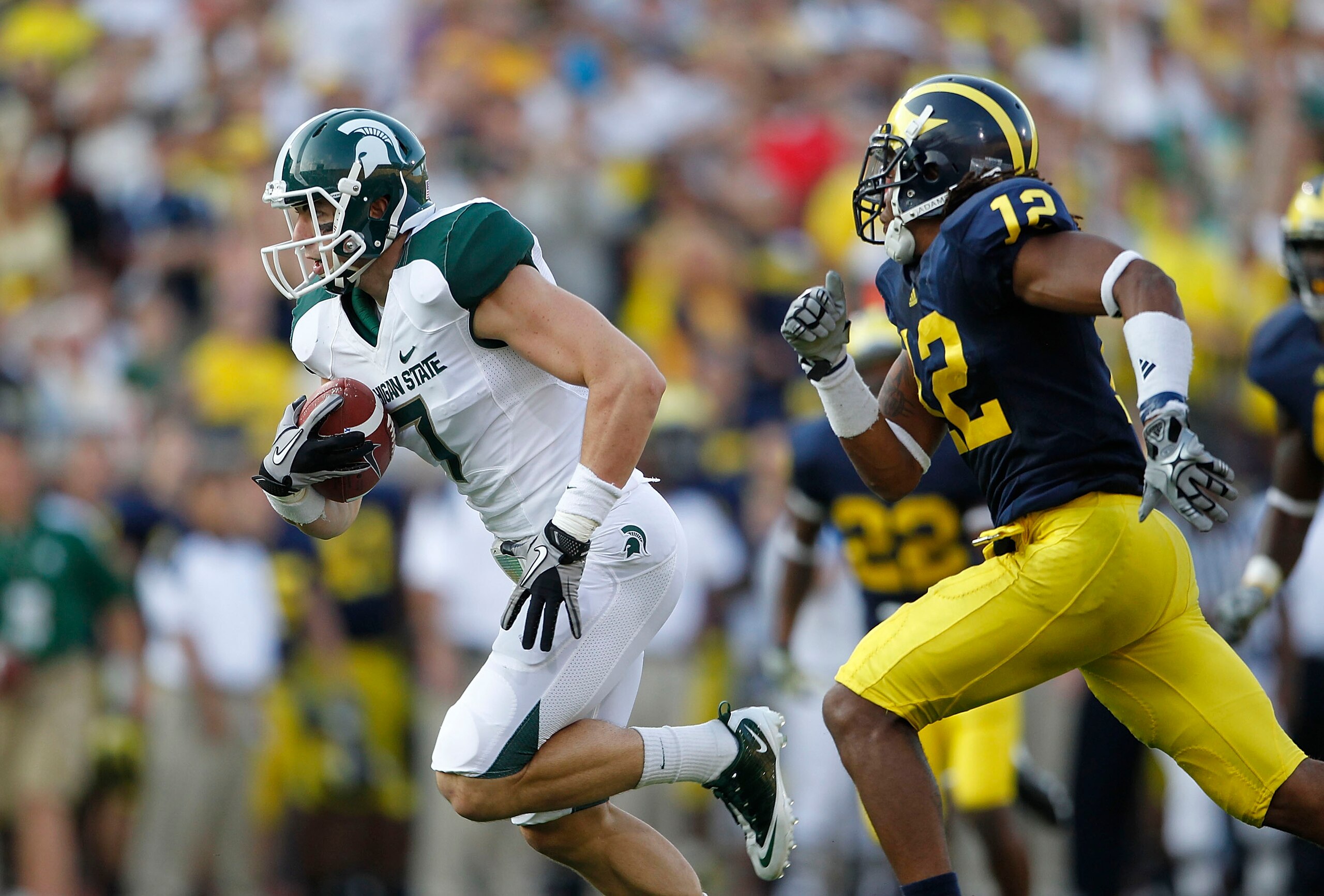 ANN ARBOR, MI - OCTOBER 09: Steve Nichol #7 of the Michigan State Spartans runs past J. T. Floyd #12 of the Michigan Wolverines after catching a 42 yard pass compleation from Kirk Cousins #8 during the third quarter of the game against the Michigan Wolve ANN ARBOR, MI - OCTOBER 09: Steve Nichol #7 of the Michigan State Spartans runs past J. T. Floyd #12 of the Michigan Wolverines after catching a 42 yard pass compleation from Kirk Cousins #8 during the third quarter of the game against the Michigan Wolve