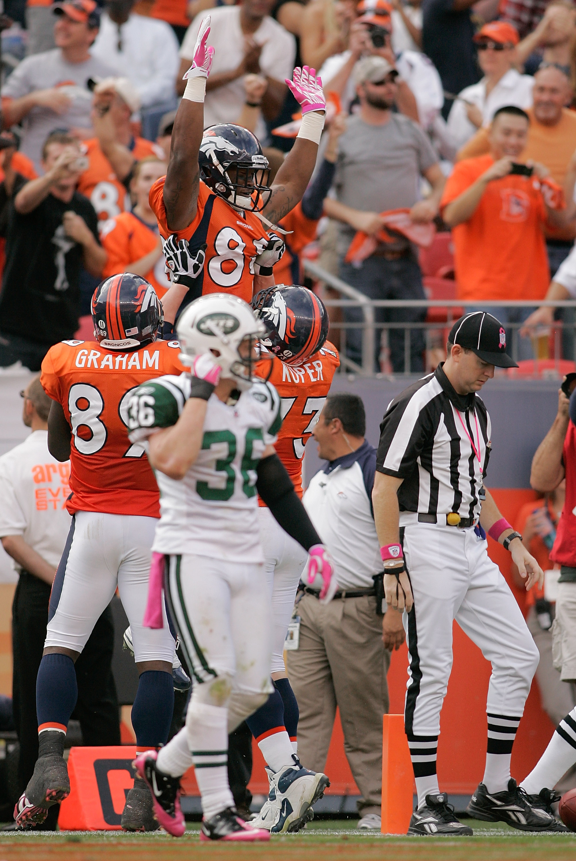DENVER - OCTOBER 17:  Wide receiver Demaryius Thomas #88 of the Denver Broncos celebrates his touchdown with teammates Daniel Graham #89 and Chris Kuper #73 as safety Jim Leonhard #36 the New York Jets walks off at INVESCO Field at Mile High on October 17