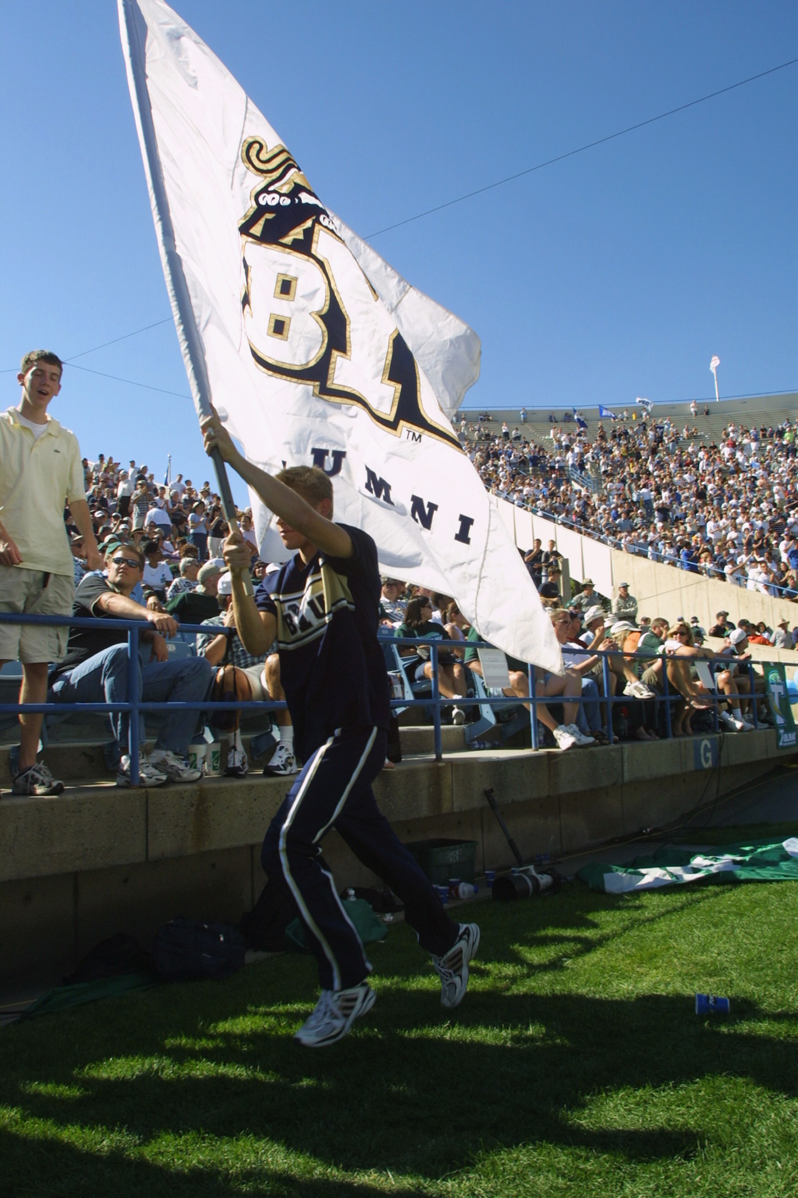 PROVO, UTAH - AUGUST 25: A spirit squad member runs along the stands with a BYU alumni flag against Tulane during the Black Coaches Association Classic at LaVelle Edwards Stadium in Provo, Utah. BYU defeated Tulane 70-35. (Photo by Jeff Gross/Getty Ima PROVO, UTAH - AUGUST 25: A spirit squad member runs along the stands with a BYU alumni flag against Tulane during the Black Coaches Association Classic at LaVelle Edwards Stadium in Provo, Utah. BYU defeated Tulane 70-35. (Photo by Jeff Gross/Getty Ima