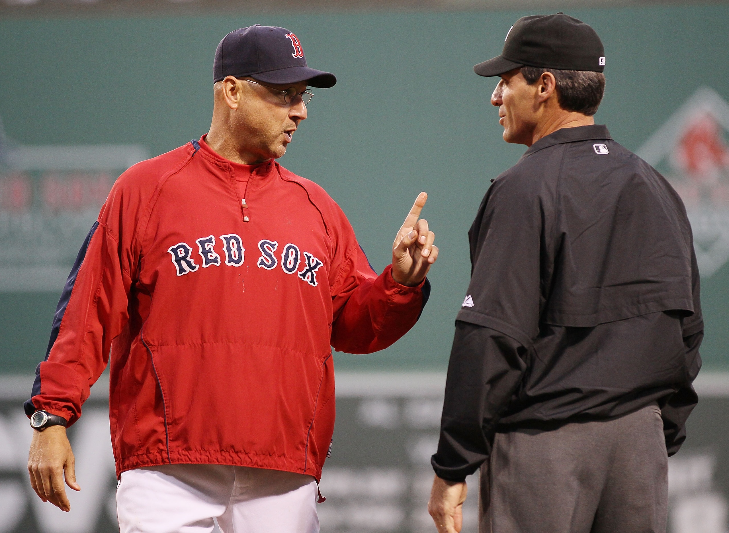 BOSTON - MAY 27:  Manager Terry Francona #47 of the Boston Red Sox discusses a call with first base umpire Angel Hernandez #55 after Jason Varitek was called out at first in the third inning against the Kansas City Royals on May 27, 2010 at Fenway Park in