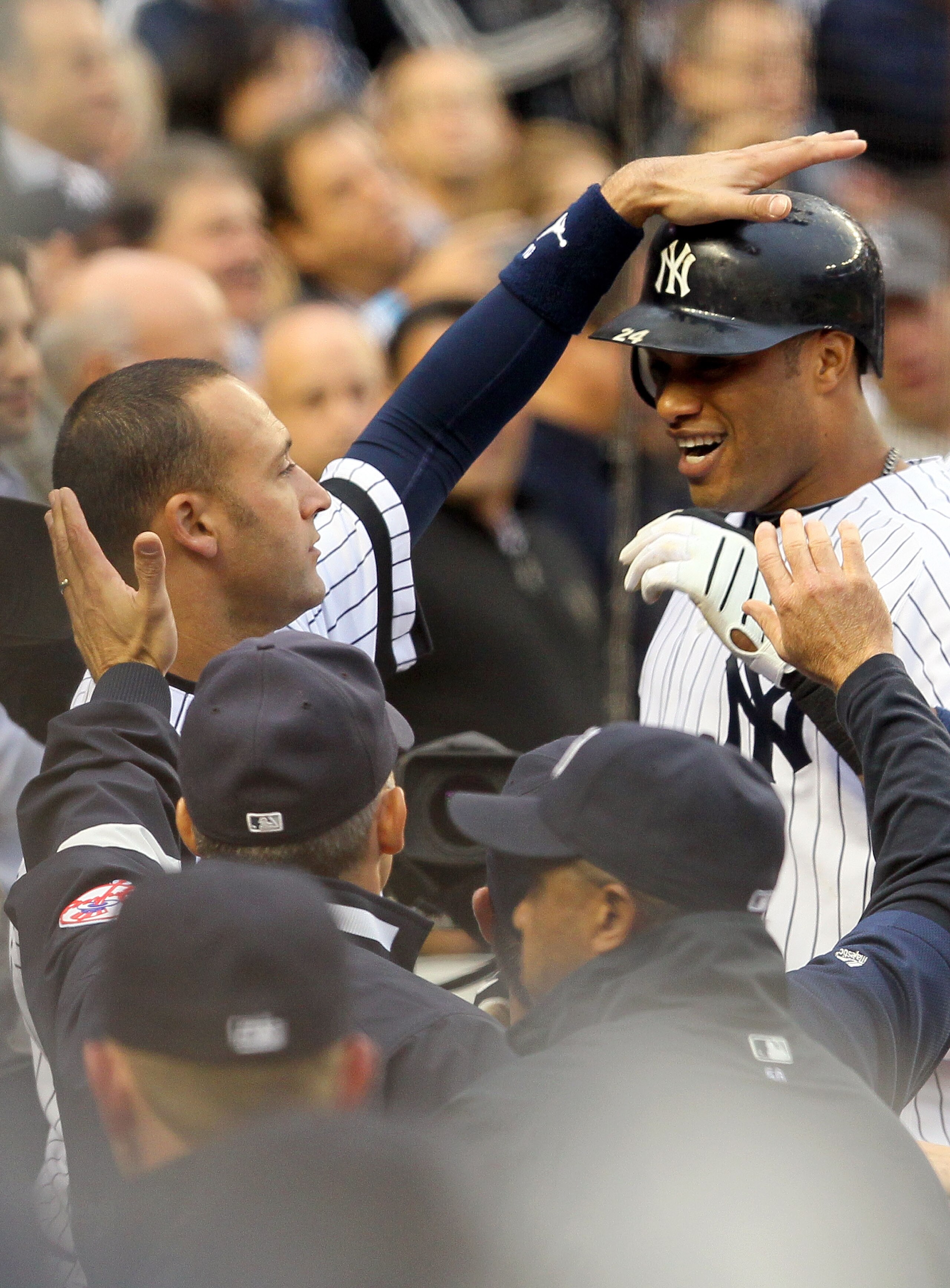 NEW YORK - OCTOBER 20:  Robinson Cano #24 and Derek Jeter #2 (L) of the New York Yankees celebrate in the dugout after Cano hit a solo home run in the third inning against the Texas Rangers in Game Five of the ALCS during the 2010 MLB Playoffs at Yankee S