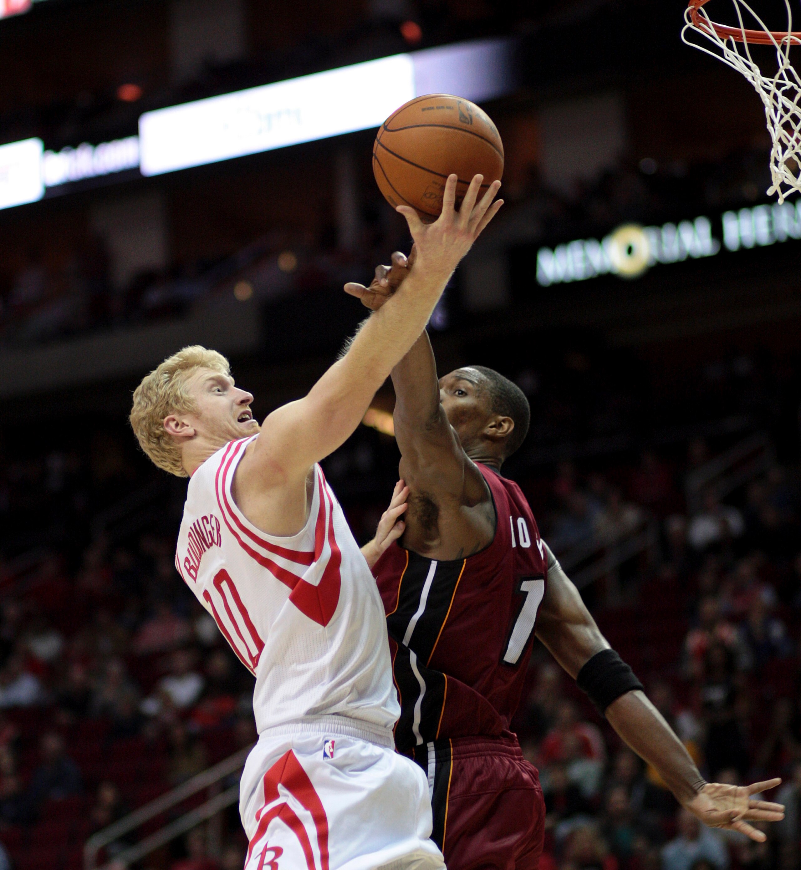 HOUSTON - DECEMBER 29: Chase Budinger #10 of the Houston Rockets drives the basket over Chris Bosh #1 of the Miami Heat in the second half at Toyota Center on December 29, 2010 in Houston, Texas. Miami won 125-119. NOTE TO USER: User expressly acknowledge HOUSTON - DECEMBER 29: Chase Budinger #10 of the Houston Rockets drives the basket over Chris Bosh #1 of the Miami Heat in the second half at Toyota Center on December 29, 2010 in Houston, Texas. Miami won 125-119. NOTE TO USER: User expressly acknowledge