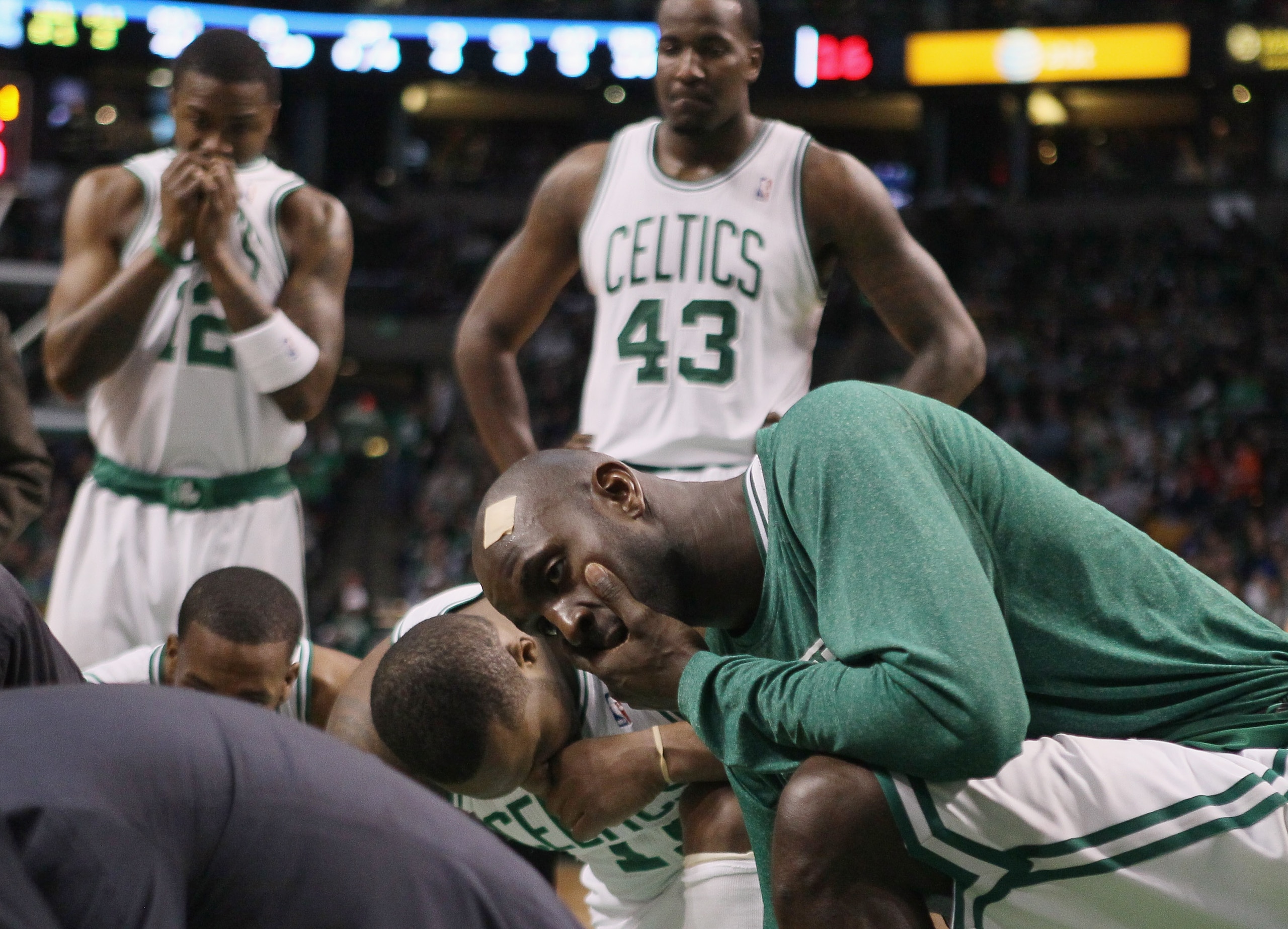BOSTON, MA - FEBRUARY 06: Kevin Garnett #5,Glen Davis #11,Kendrick Perkins #43 and Von Wafter #12 of the Boston Celtics watch as medical personnel tend to Marquis Daniels of the Celtics after Daniels collided with Gilbert Arenas of the Orlando Magic on Fe