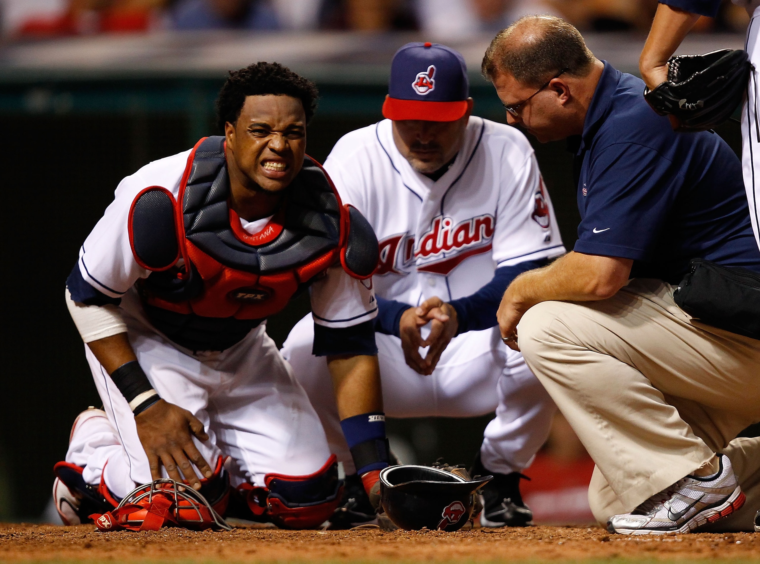 CLEVELAND - JULY 29: Carlos Santana #41 of the Cleveland Indians grimaces in pain in front of Manager Manny Acta #11 after a ball hit him in the knee during the game against the New York Yankees on July 29, 2010 at Progressive Field in Cleveland, Ohio. CLEVELAND - JULY 29: Carlos Santana #41 of the Cleveland Indians grimaces in pain in front of Manager Manny Acta #11 after a ball hit him in the knee during the game against the New York Yankees on July 29, 2010 at Progressive Field in Cleveland, Ohio.