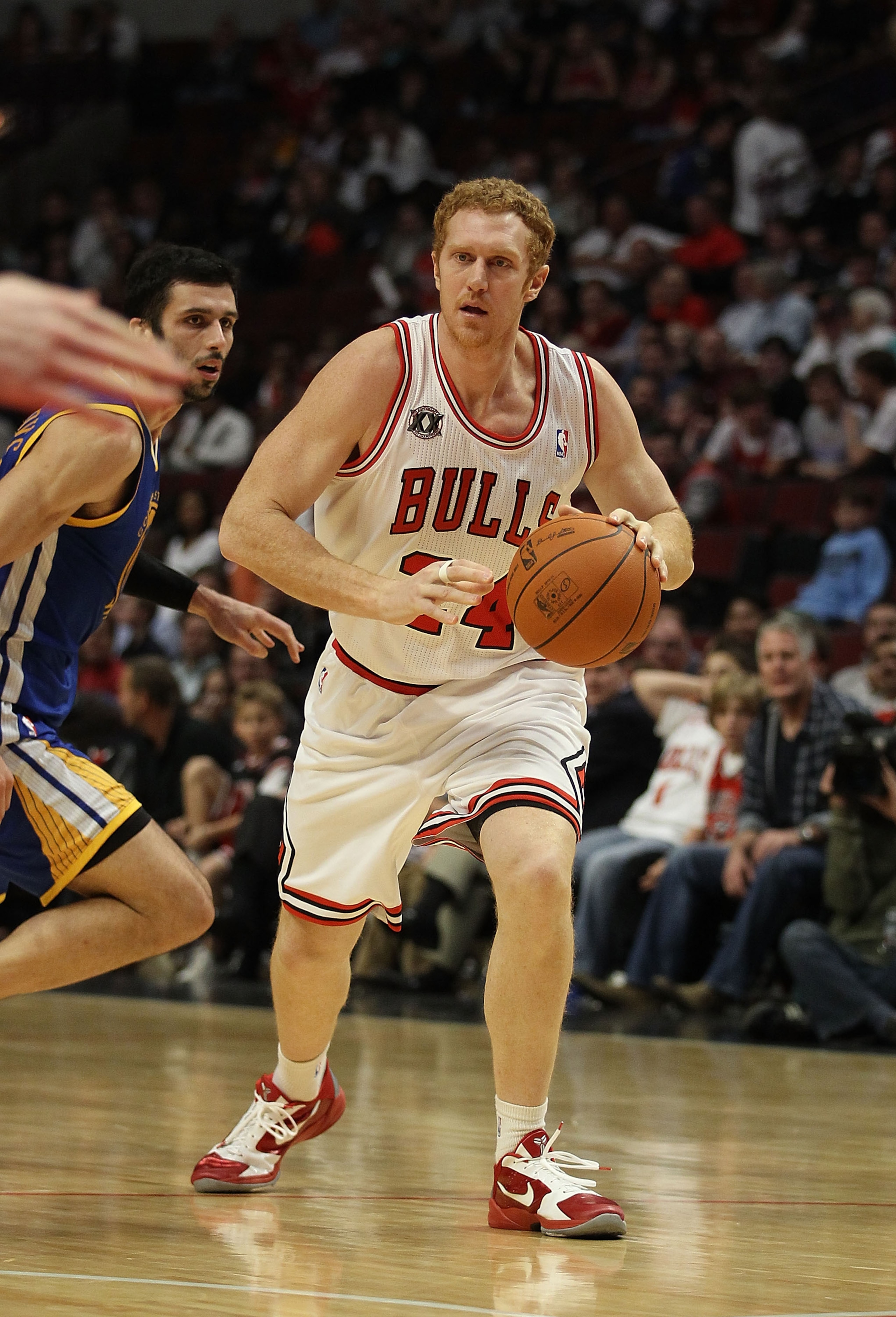 CHICAGO, IL - NOVEMBER 11: Brian Scalabrine #24 of the Chicago Bulls moves past Valdimir Radmanovic #77 of the Golden State Warriors at the United Center on November 11, 2010 in Chicago, Illinois. The Bulls defeated the Warriors 120-90. NOTE TO USER: User