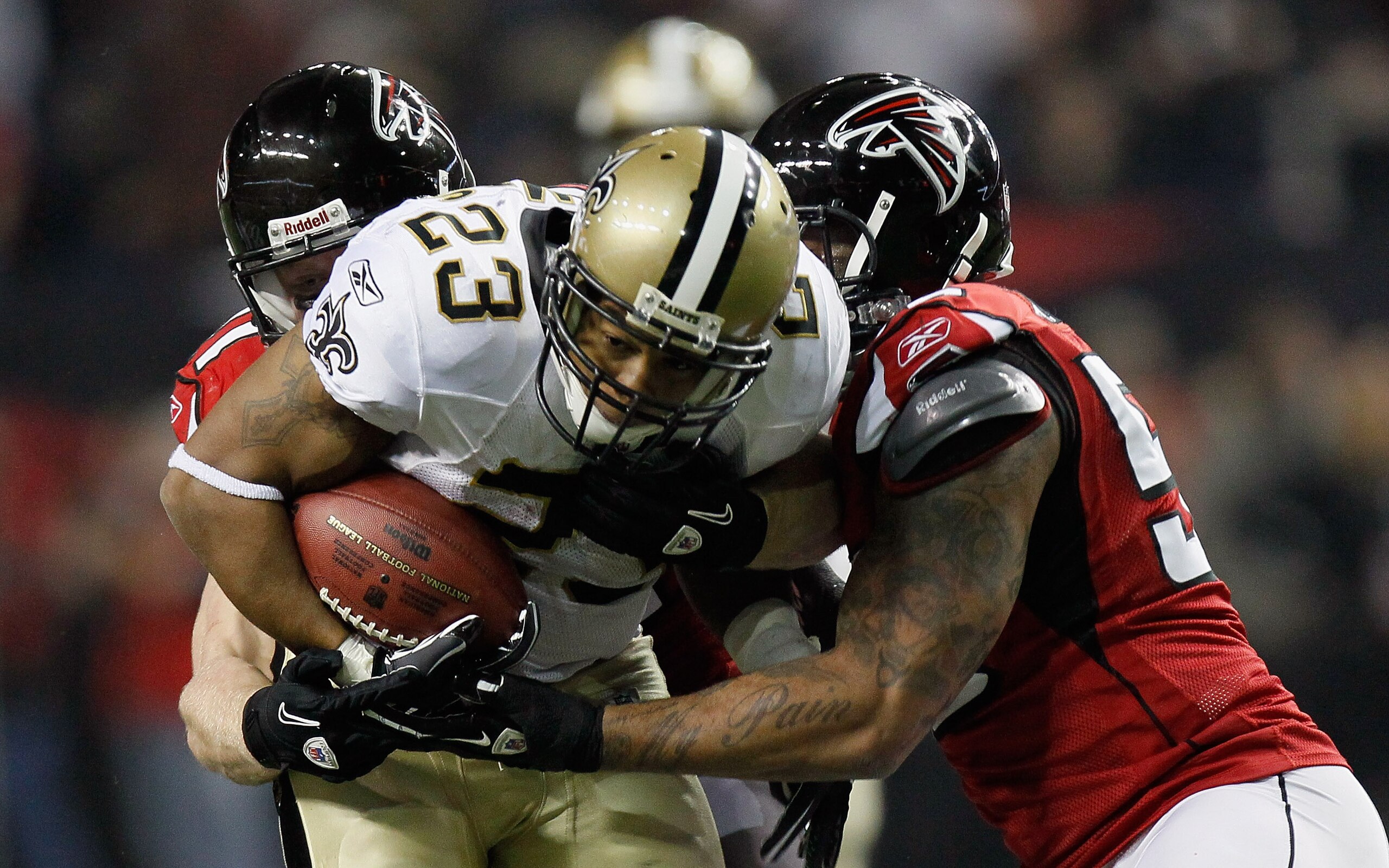 ATLANTA, GA - DECEMBER 27: Pierre Thomas #23 of the New Orleans Saints fights off two defenders in the first half during the game against the Atlanta Falcons at the Georgia Dome on December 27, 2010 in Atlanta, Georgia. (Photo by Kevin C. Cox/Getty Imag ATLANTA, GA - DECEMBER 27: Pierre Thomas #23 of the New Orleans Saints fights off two defenders in the first half during the game against the Atlanta Falcons at the Georgia Dome on December 27, 2010 in Atlanta, Georgia. (Photo by Kevin C. Cox/Getty Imag