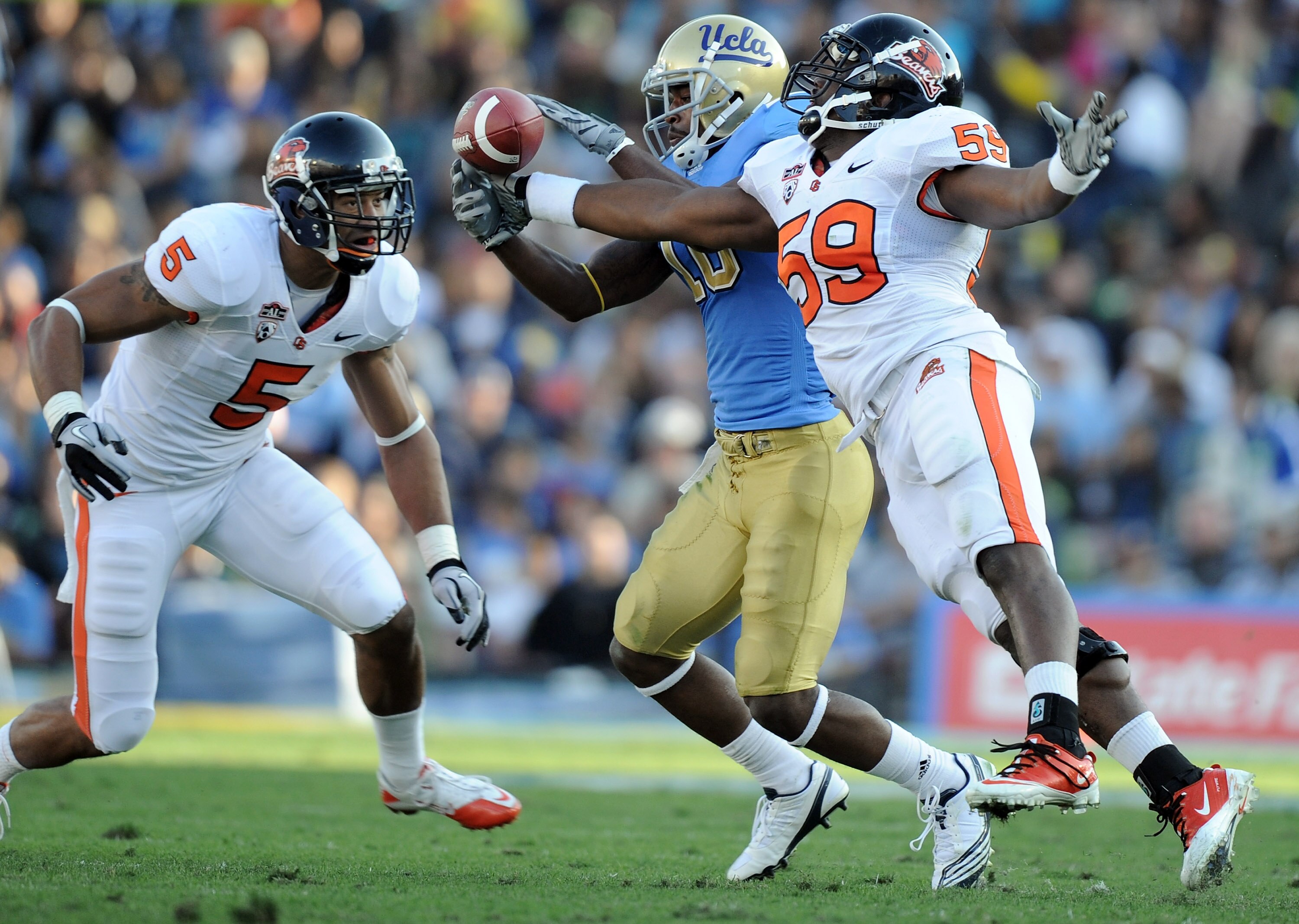 PASADENA, CA - NOVEMBER 06:  Akeem Ayers #10 of the UCLA Bruins makes a catch in front of Dwight Roberson #59 and Cameron Collins #5 of the Oregon State Beavers at the Rose Bowl on November 6, 2010 in Pasadena, California.  (Photo by Harry How/Getty Image