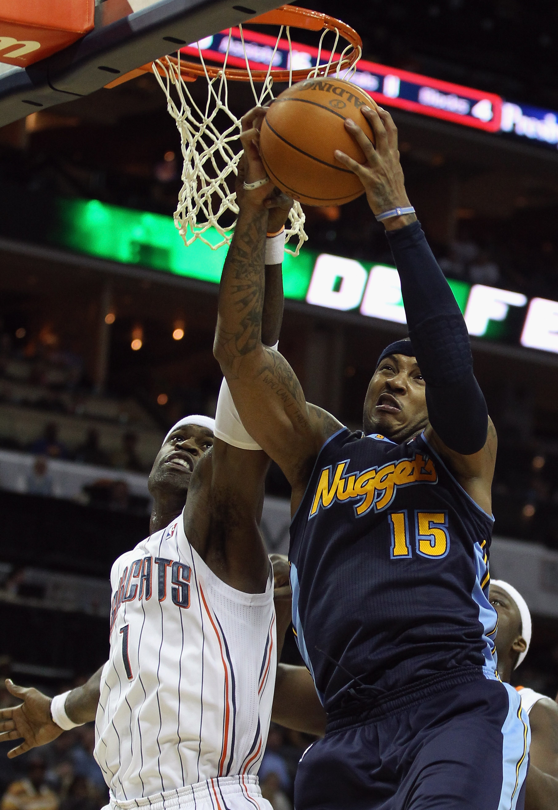 CHARLOTTE, NC - DECEMBER 07:  Carmelo Anthony #15 of the Denver Nuggets grabs a rebound over Stephen Jackson #1 of the Charlotte Bobcats during their game at Time Warner Cable Arena on December 7, 2010 in Charlotte, North Carolina.  NOTE TO USER: User exp