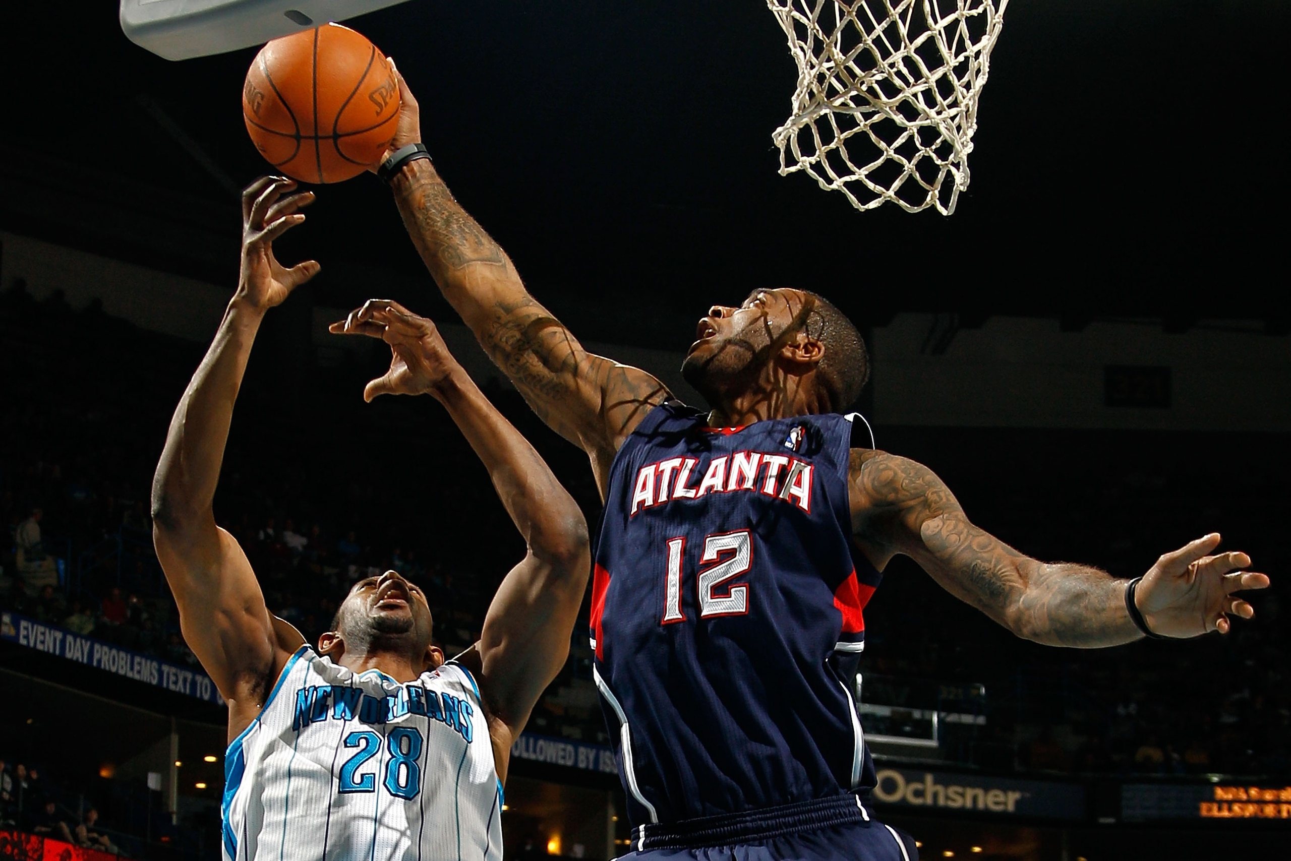NEW ORLEANS, LA - DECEMBER 26:  D.J. Mbenga #28 of the New Orleans Hornets fights for a rebound with Josh Powell #12 of the Atlanta Hawks at the New Orleans Arena on December 26, 2010 in New Orleans, Louisiana.  NOTE TO USER: User expressly acknowledges a