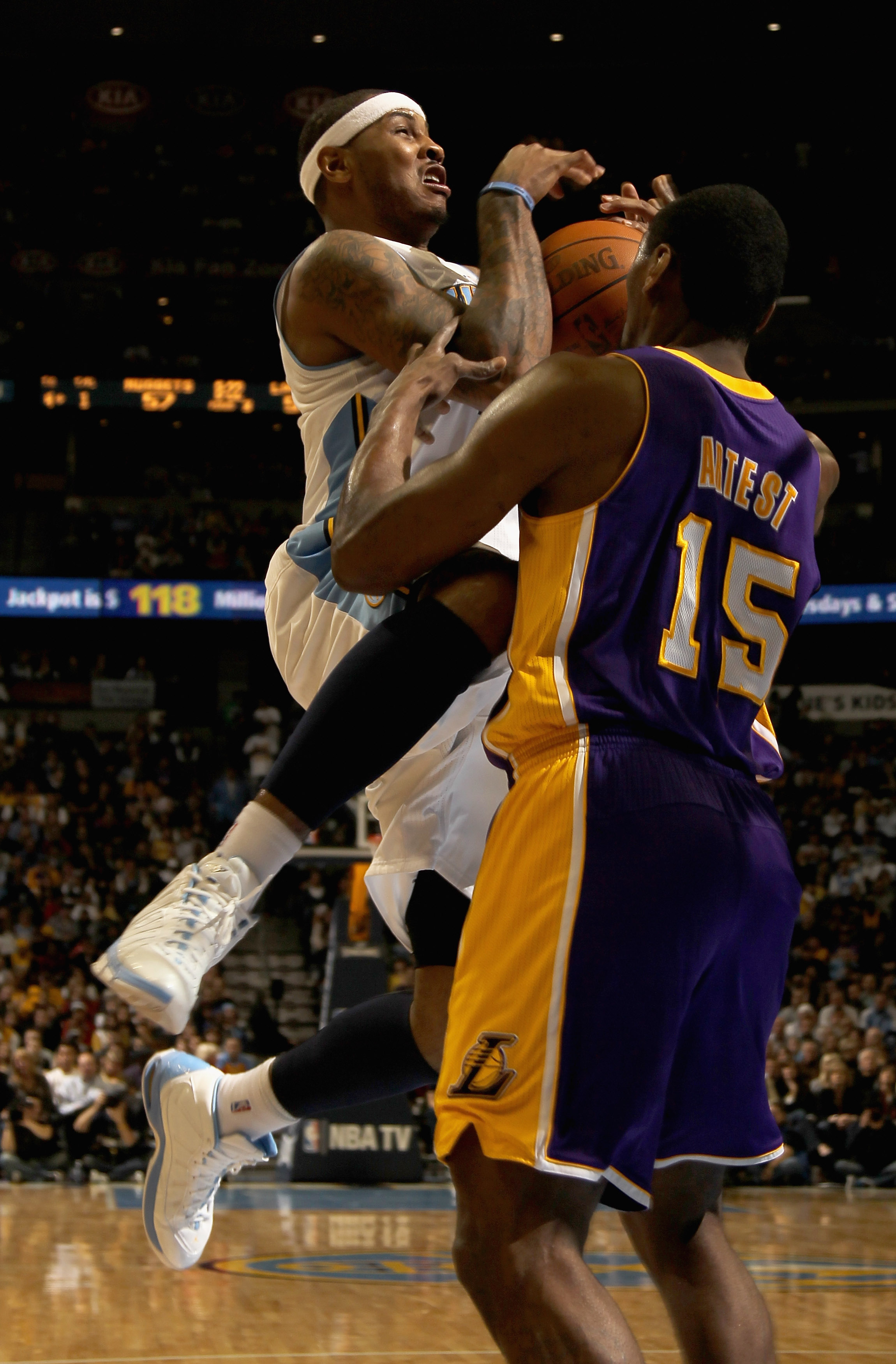 DENVER, CO - JANUARY 21:  Carmelo Anthony #15 of the Denver Nuggets is fouled by Ron Artest #15 of the Los Angeles Lakers at the Pepsi Center on January 21, 2011 in Denver, Colorado. The Lakers defeated the Nuggets 107-97. NOTE TO USER: User expressly ack