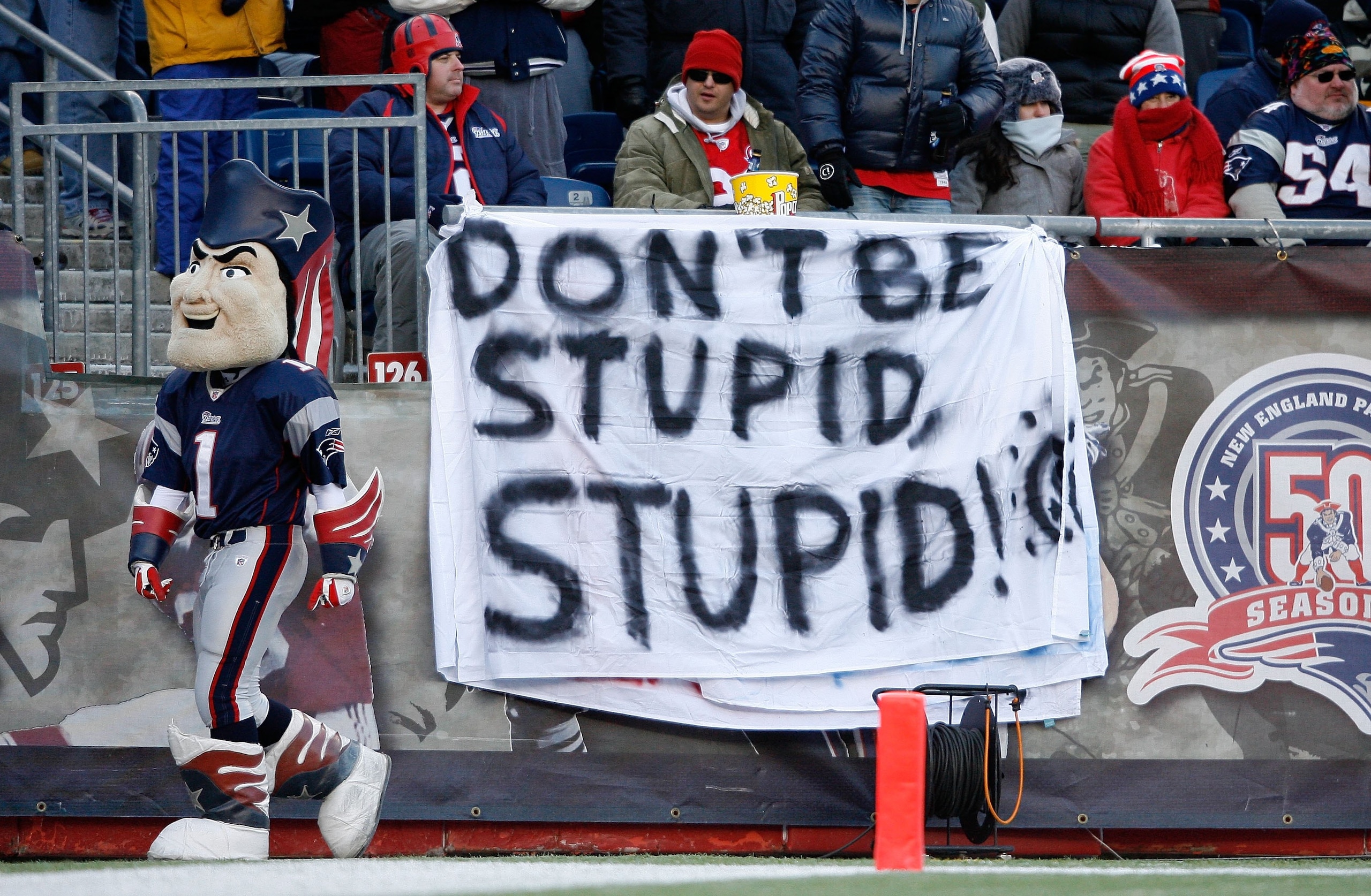 FOXBORO, MA - JANUARY 10:  Fans of the New England Patriots hold up a sign which reads 'Don't Be Stupid, Stupid!' against the Baltimore Ravens during the 2010 AFC wild-card playoff game at Gillette Stadium on January 10, 2010 in Foxboro, Massachusetts.  (