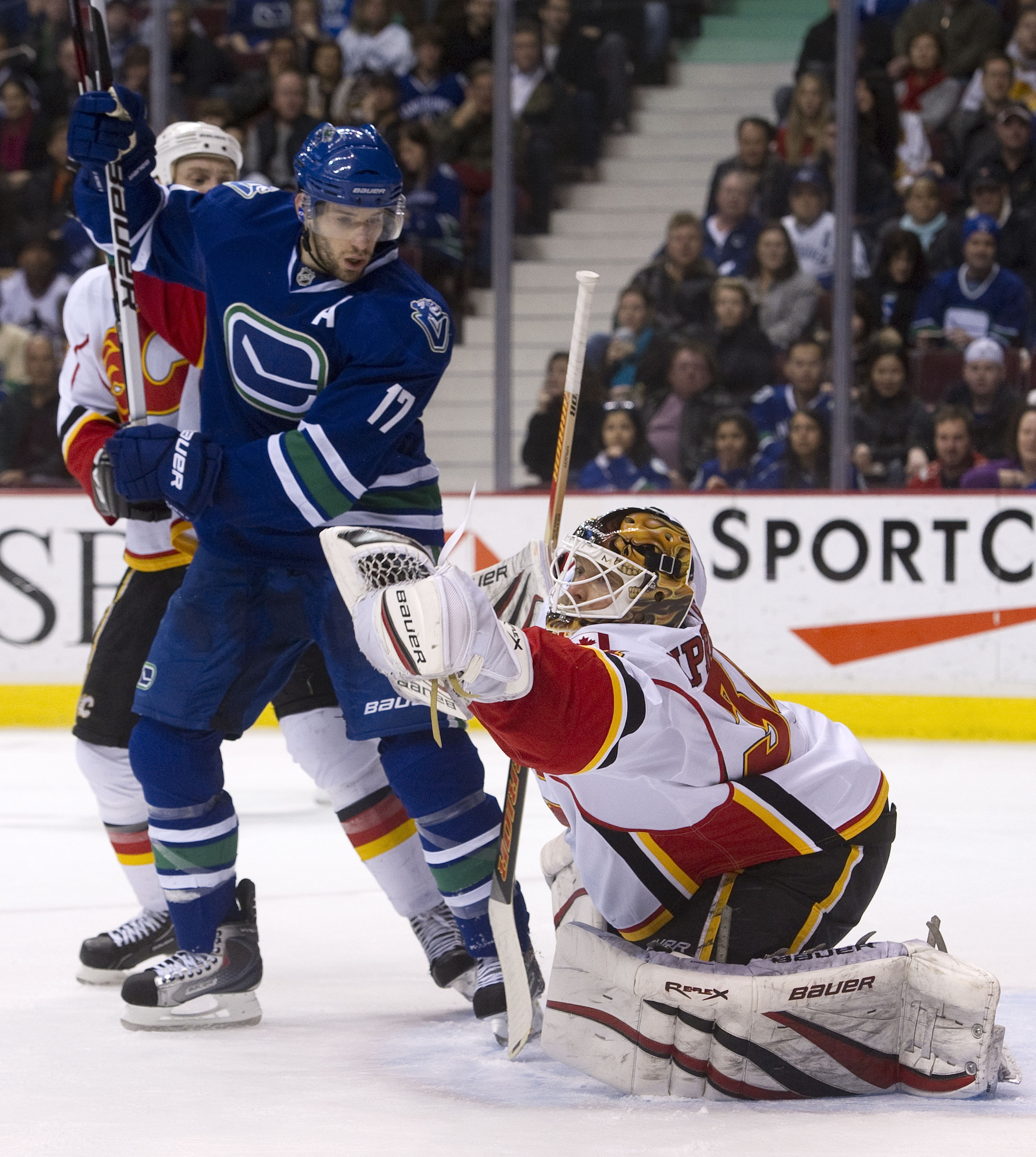 VANCOUVER, CANADA - JANUARY 22: Ryan Kesler #17 of the Vancouver Canucks watches goalie Miikka Kiprusoff #34 of the Calgary Flames make a glove save during the second period in NHL action on January 22, 2011 at Rogers Arena in Vancouver, British Columbia,