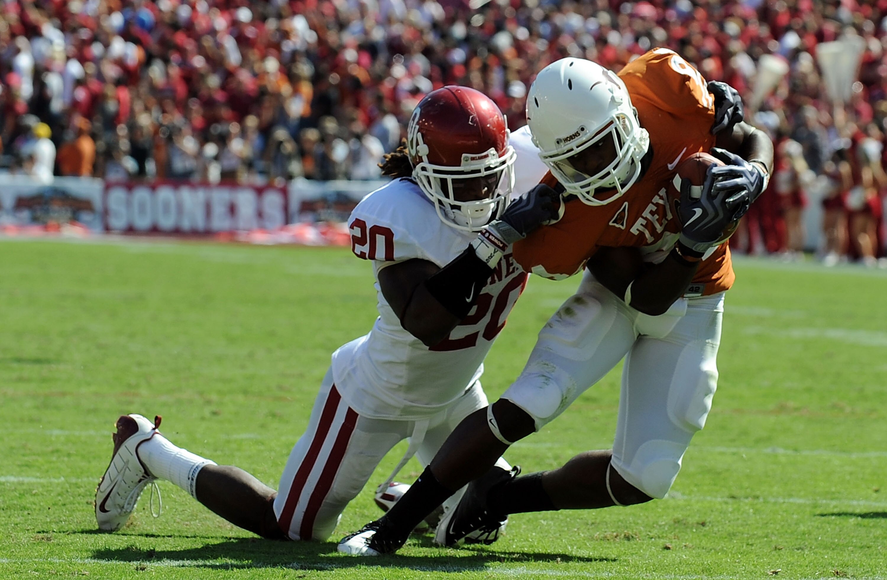 DALLAS - OCTOBER 17:  Wide receiver Marquise Goodwin #84 of the Texas Longhorns runs for a touchdown against Quinton Carter #20 of the Oklahoma Sooners at Cotton Bowl on October 17, 2009 in Dallas, Texas.  (Photo by Ronald Martinez/Getty Images)